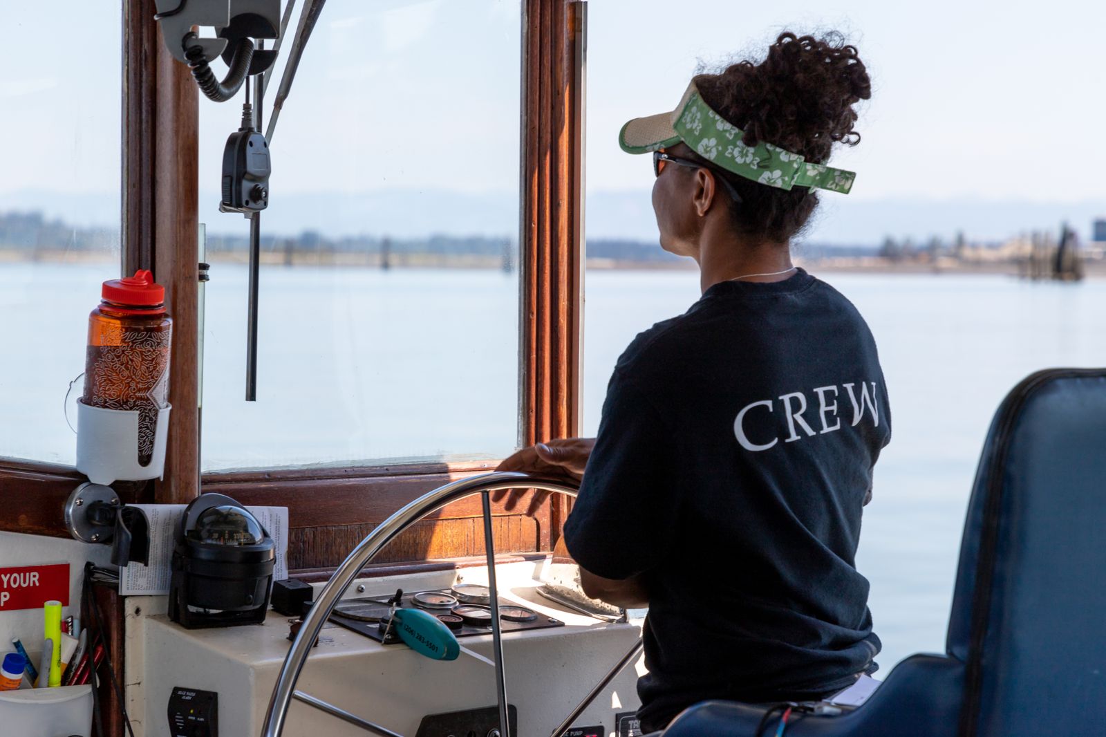 Mujer al timón de un barco.