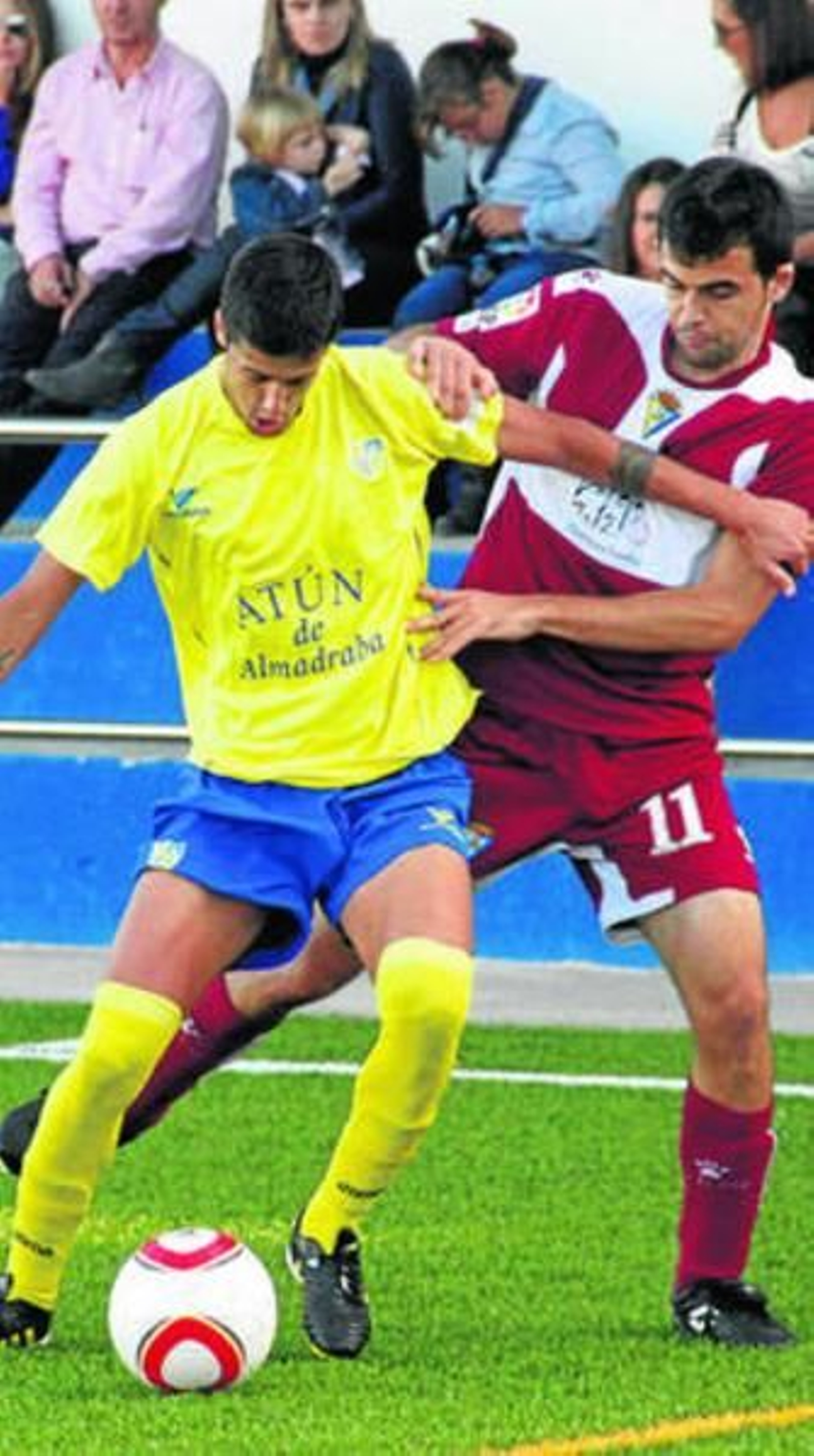Álex Cortés cubre el balón mientras le acosa Rubén Pérez.