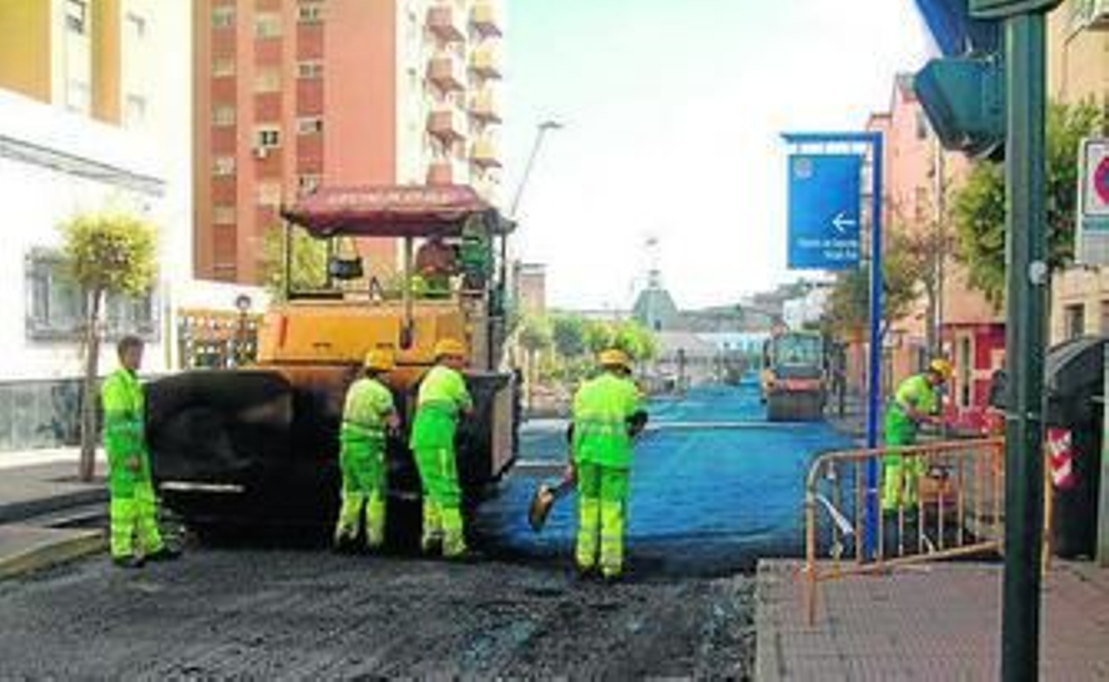 Obreros en plena labor de pavimentación de la calzada.
