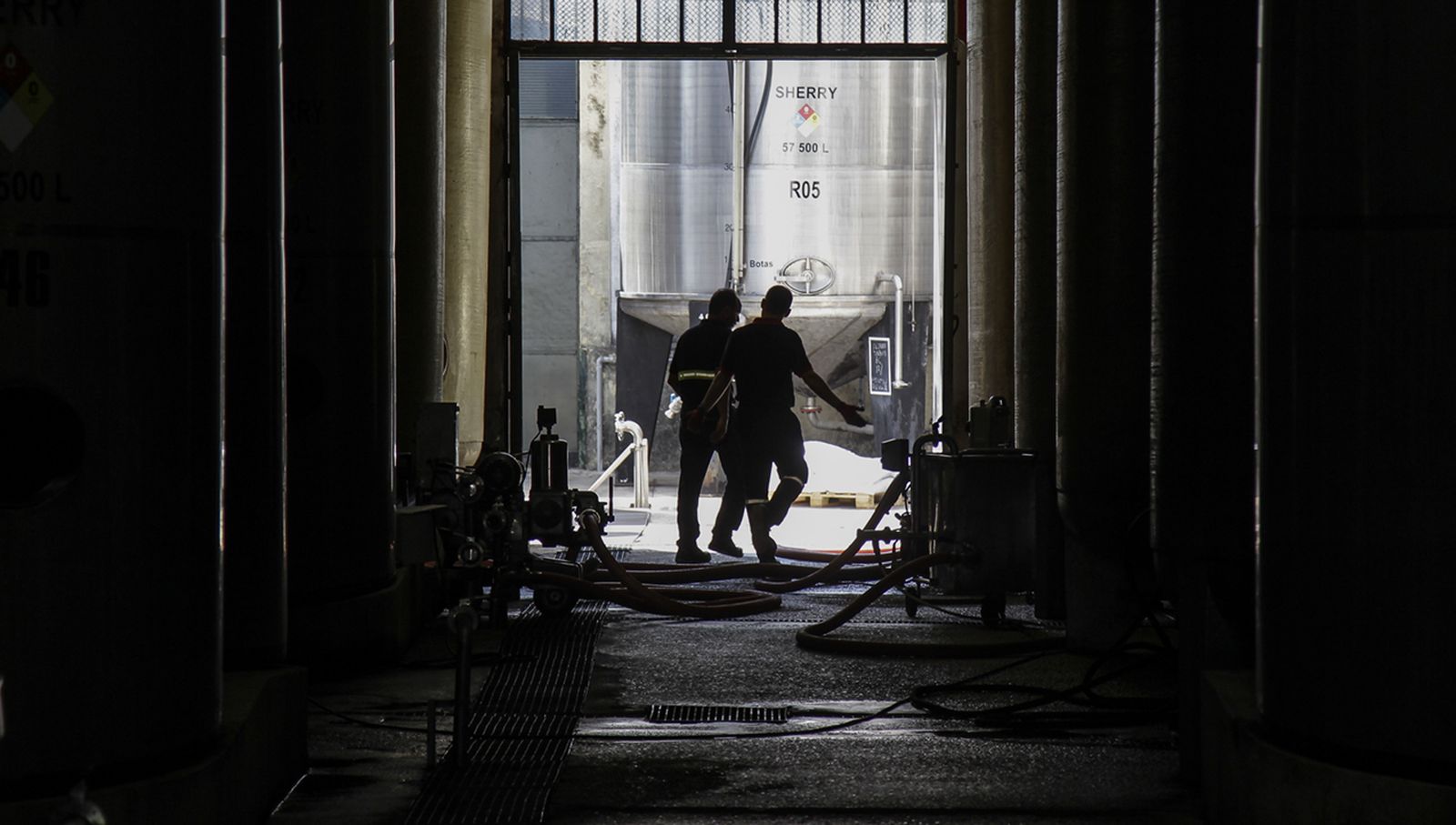 Imagen del centro de producción de Fundador, con dos operarios vistos al contraluz.