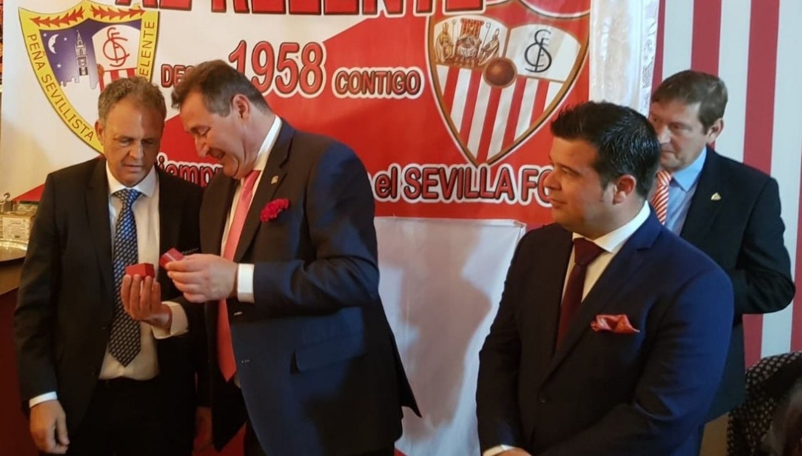 Caparrós recibe el escudo de oro de Guillermo Jiménez junto a Carlos Jiménez.