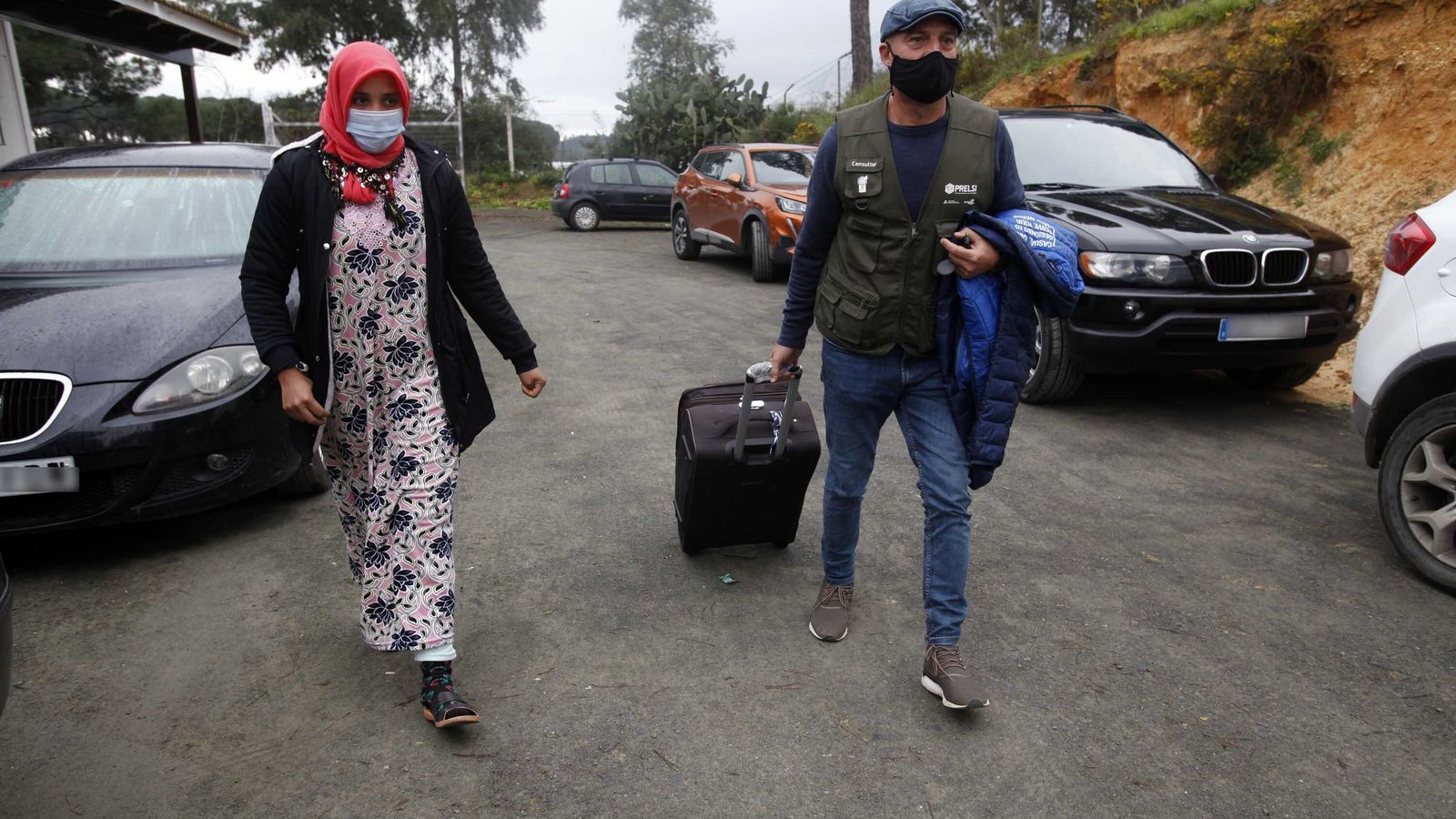 Un consultor ayuda a una temporera a transportar su equipaje