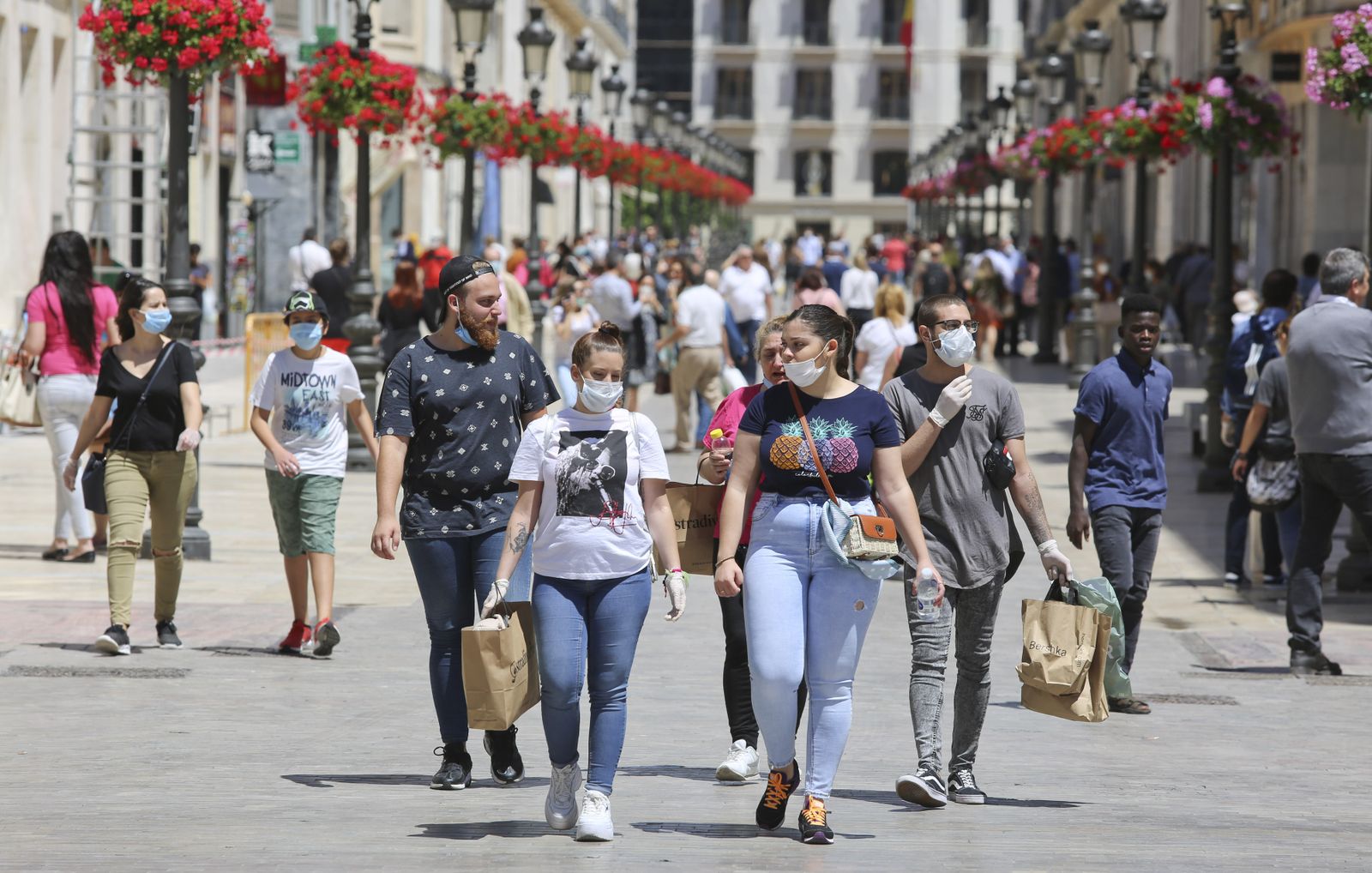Varios jóvenes con bolsas por la calle Larios en el primer día de la fase 1 de desescalada en Málaga.