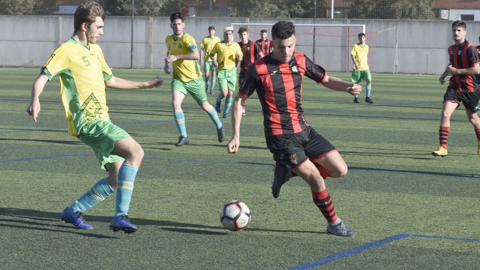 Un jugador rojinegro trata de controlar el balón en presencia de uno de la Gimnástica de Ceuta.