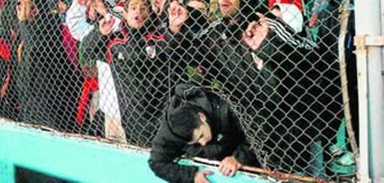 Un hincha de RIver intenta entrar al campo por un agujero de la alambrada.