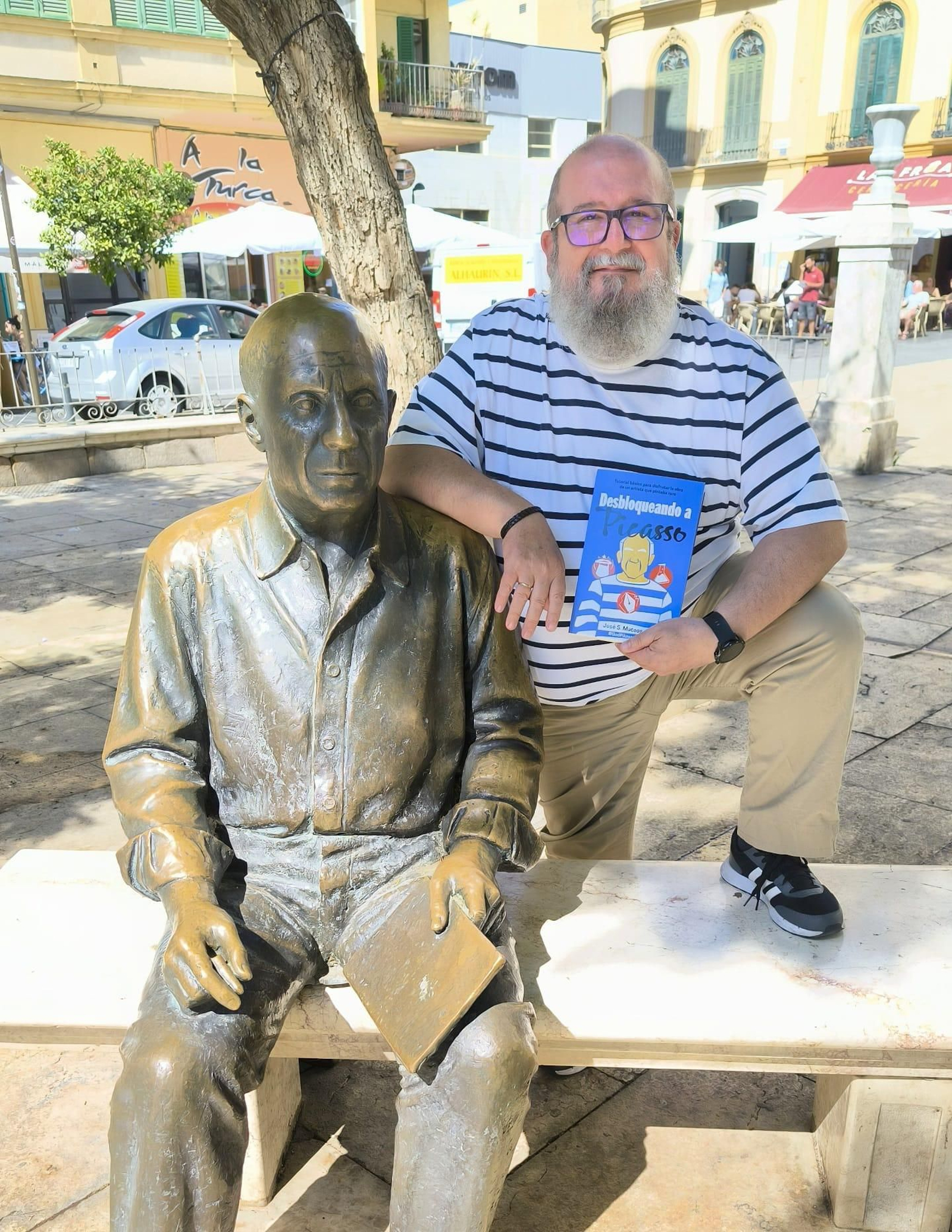 El autor José S. Mateos posa con la estatua de Picasso y el libro 'Desbloqueando a Picasso'.