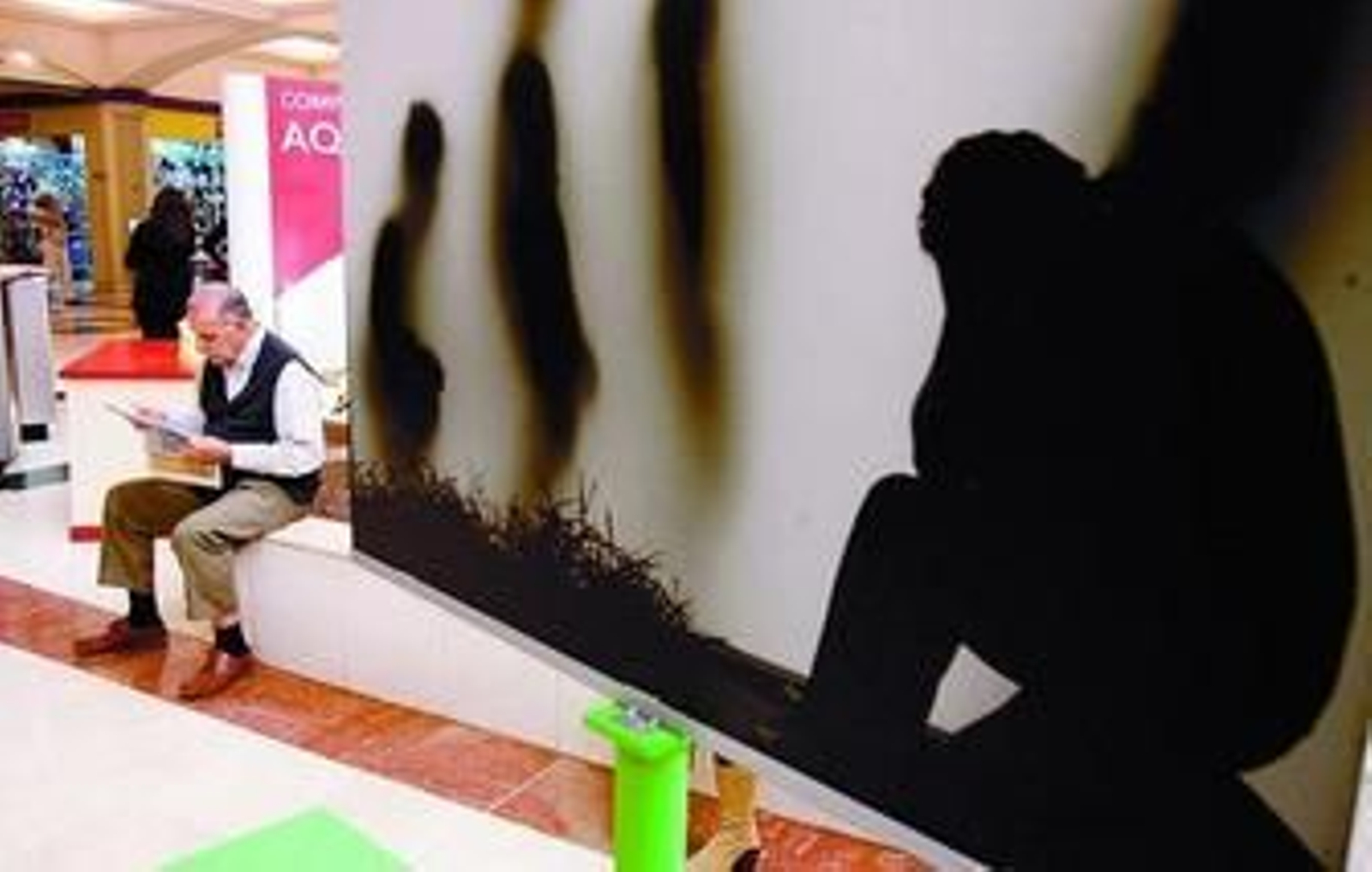 Un hombre lee la prensa junto a una obra expuesta en una jornada sobre concienciación social y salud. Un hombre lee la prensa junto a una obra expuesta en una jornada sobre concienciación social y salud.