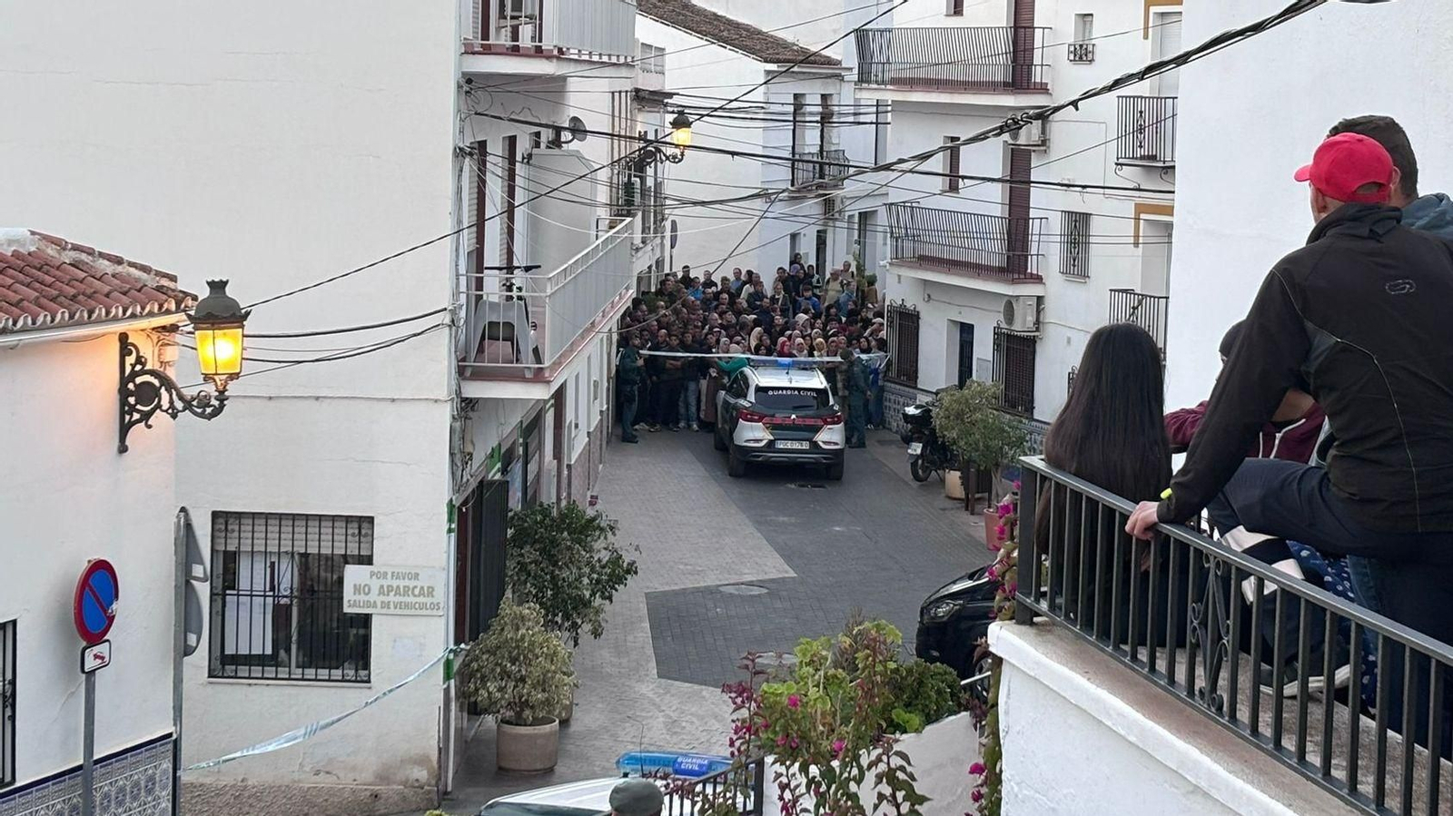 Decenas de personas tras el cordón policial junto a la vivienda de la familia fallecida en Torrox.