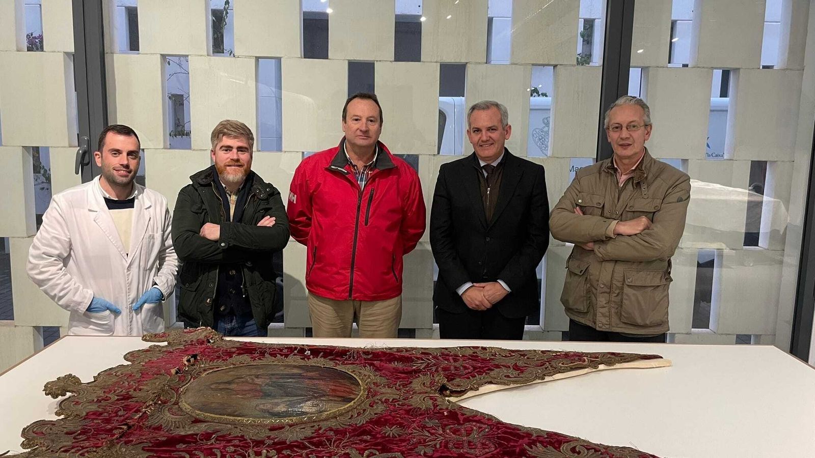 Representantes de la hermandad y de la empresa de restauración con el simpecado.