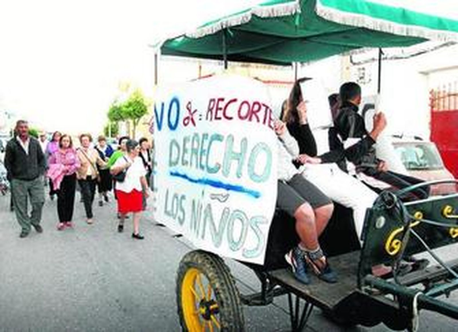 Los niños de Infantil y Primaria llegaron al colegio en charret, arropados por sus padres. A la derecha, madres, padres y alumnos, a las puertas del Juan Ramón Jiménez.