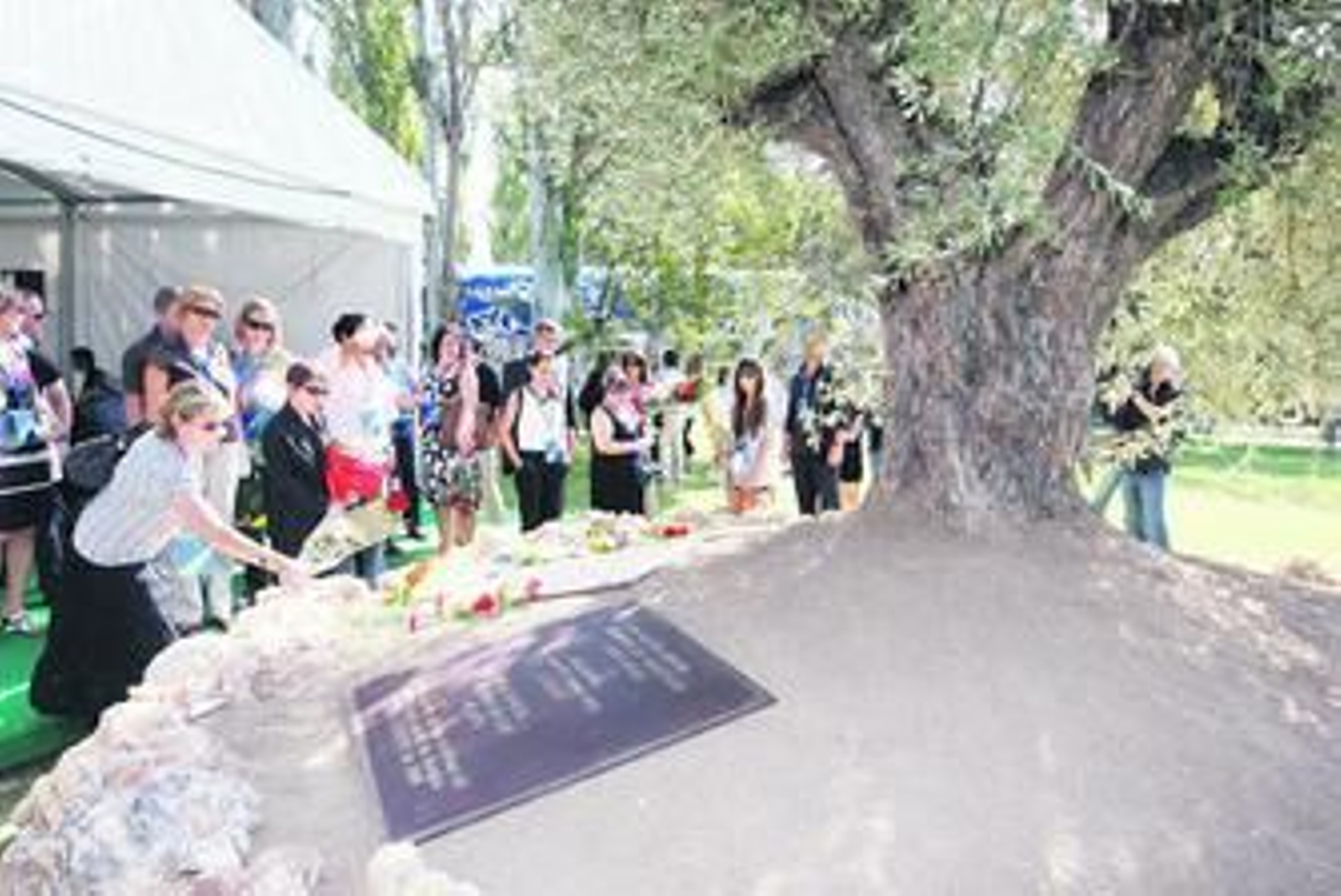 Familiares de las víctimas depositan ramos de flores en el monumento inaugurado en la terminal 2 de Barajas.