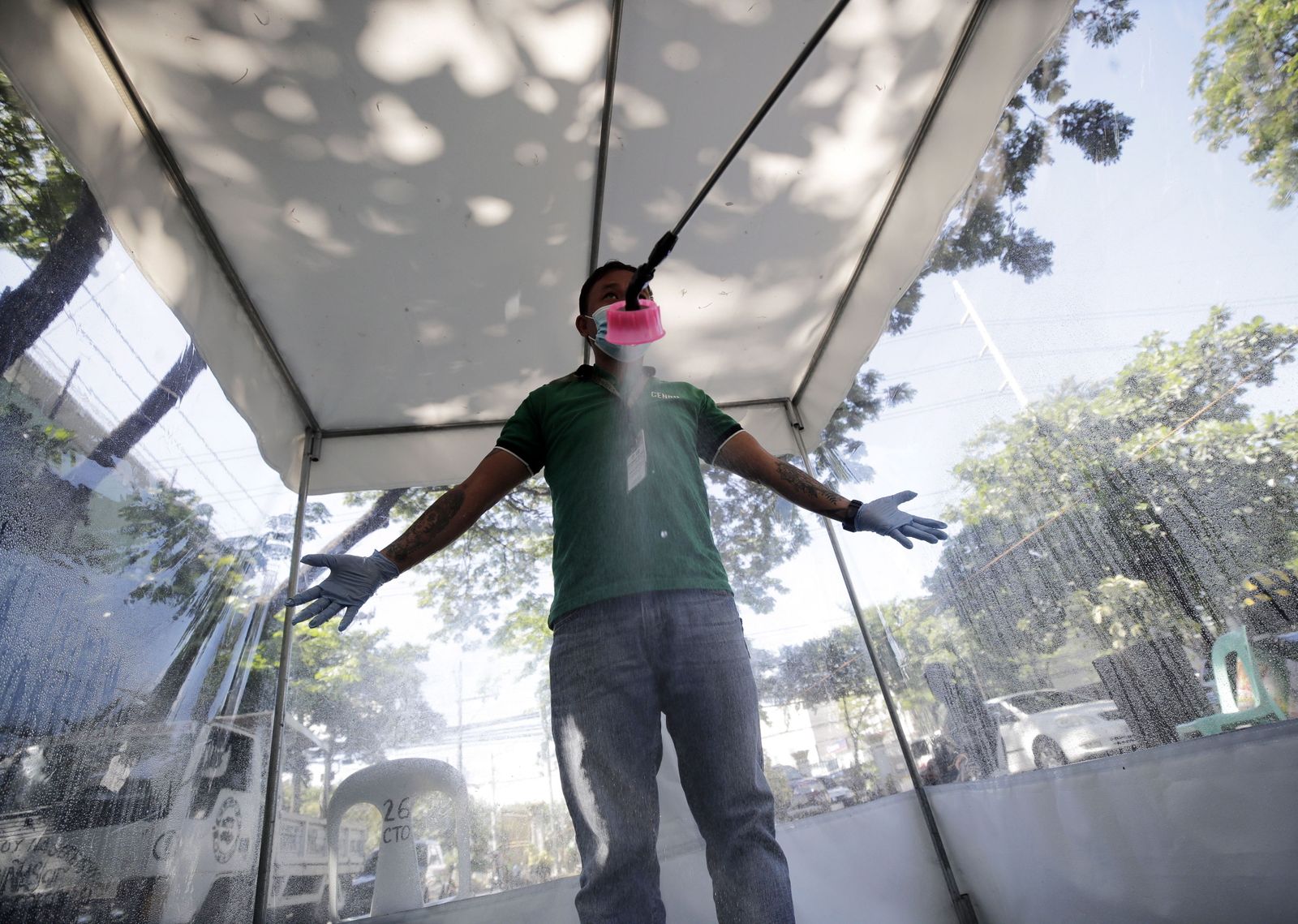 Un hombre en una cabina de desinfección en el Metro de Manila