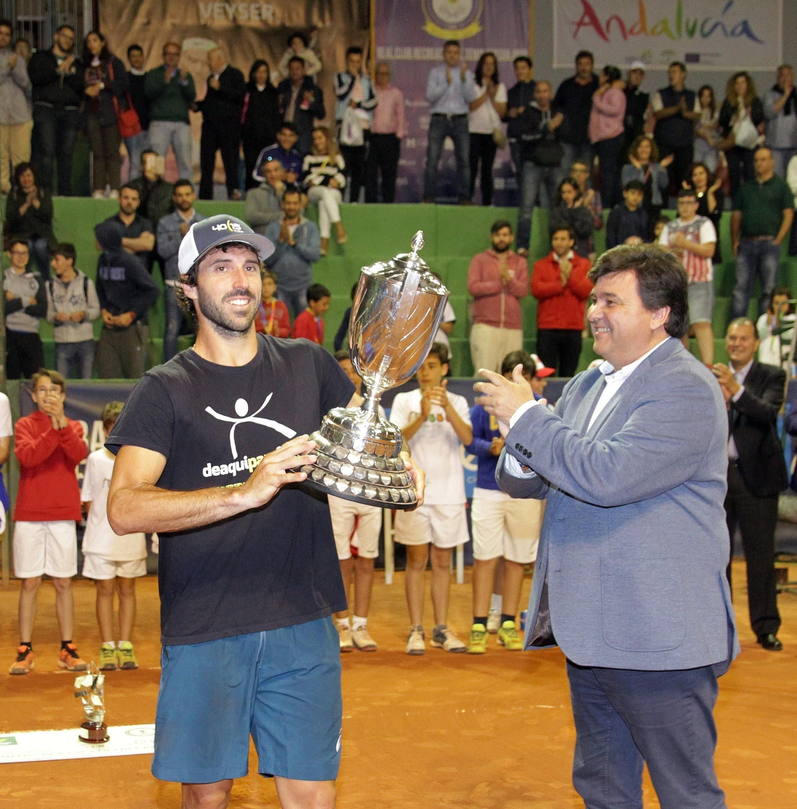 El campeón posa con el trofeo en presencia del alcalde, Gabriel Cruz, mientras los aficionados aplauden, anoche en el Real Club Recreativo de Tenis.