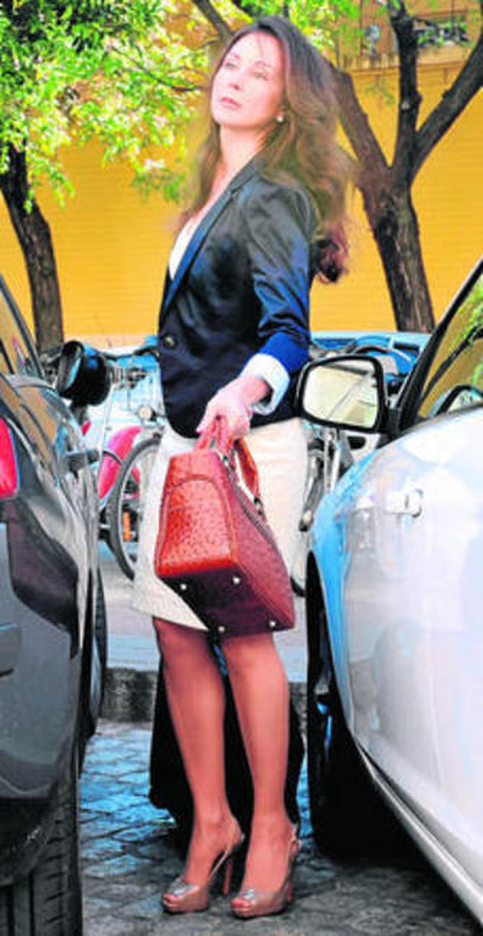 La juez Alaya se abre paso entre dos coches, en los juzgados.