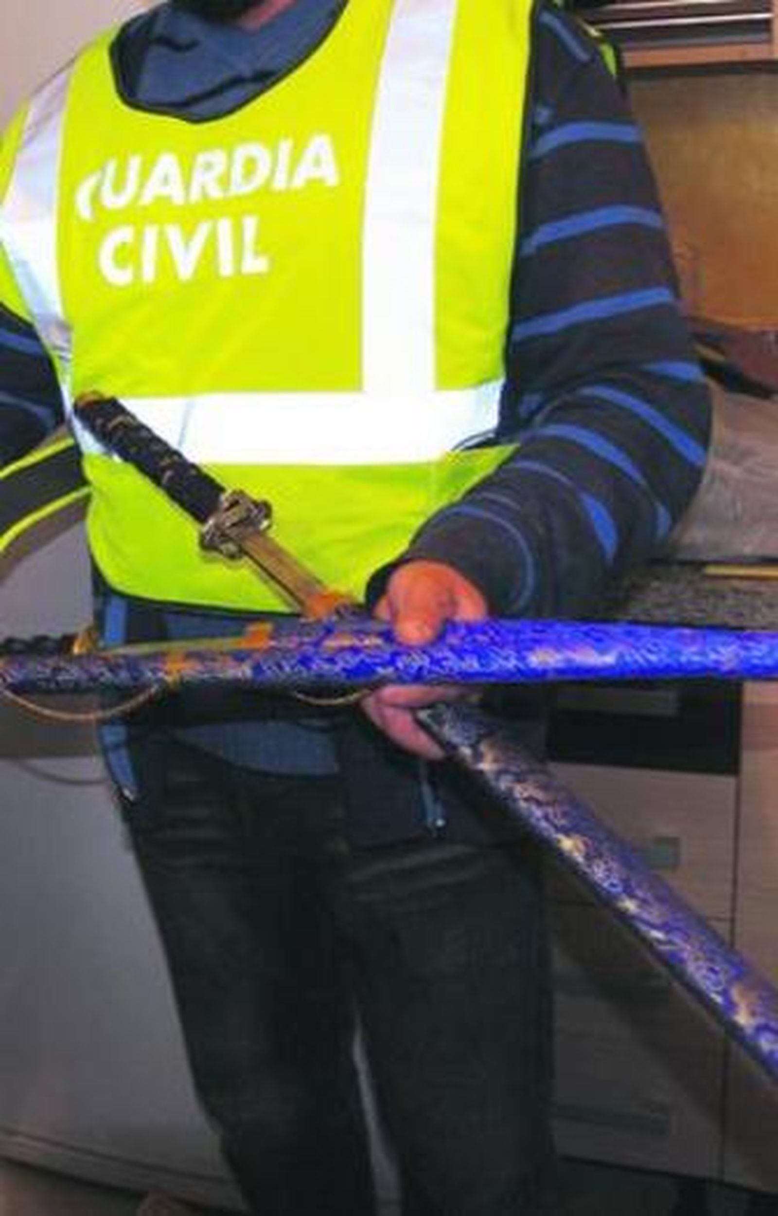 Un guardia civil muestra la catana intervenida.