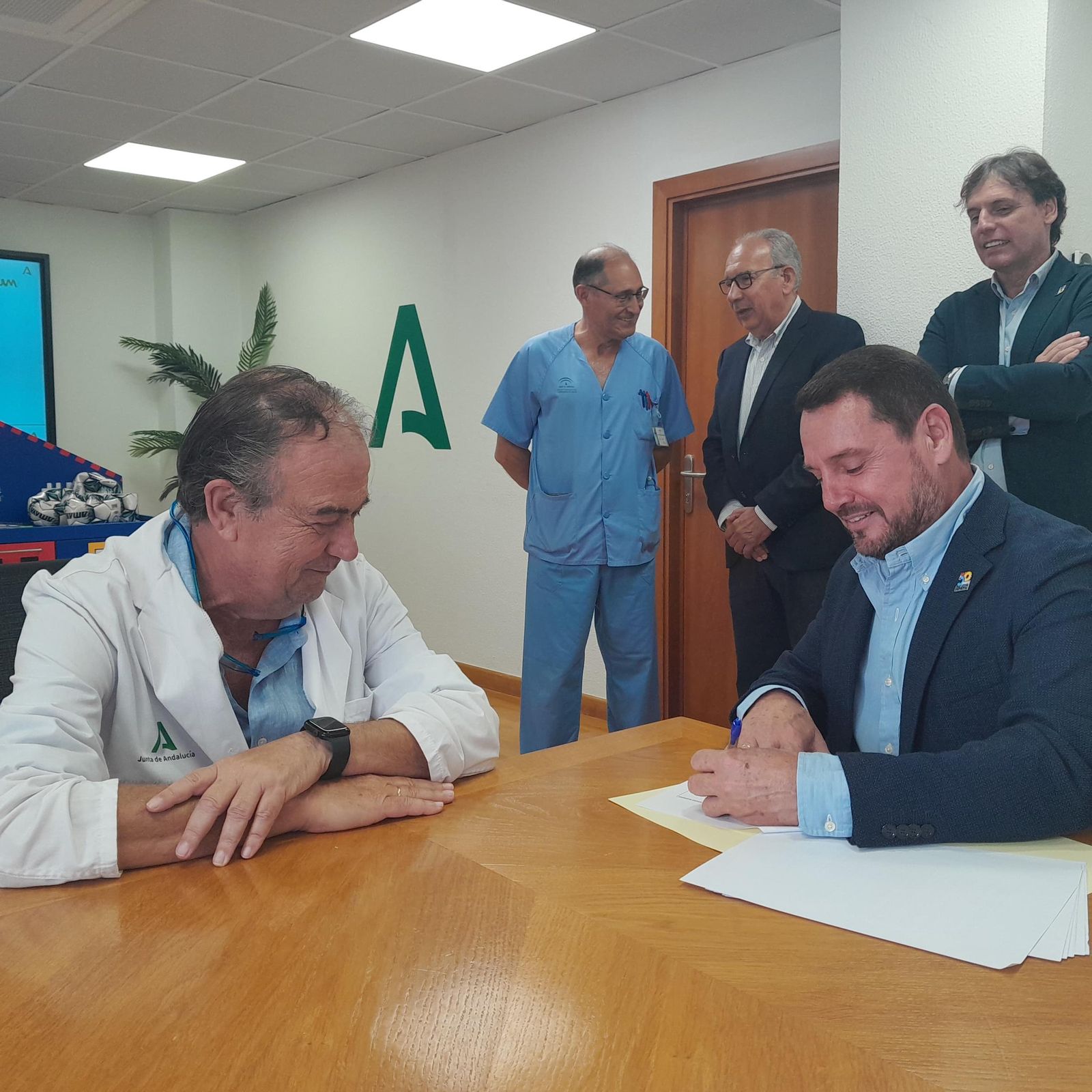 El gerente del Macarena, Miguel A. Colmenero, firmando el acuerdo de colaboración con representante de la Casa de Ronald McDonald.