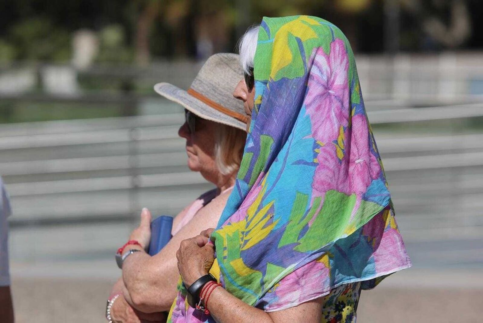 Dos turistas se protegen la cabeza del sol con sombrero y pañuelo.