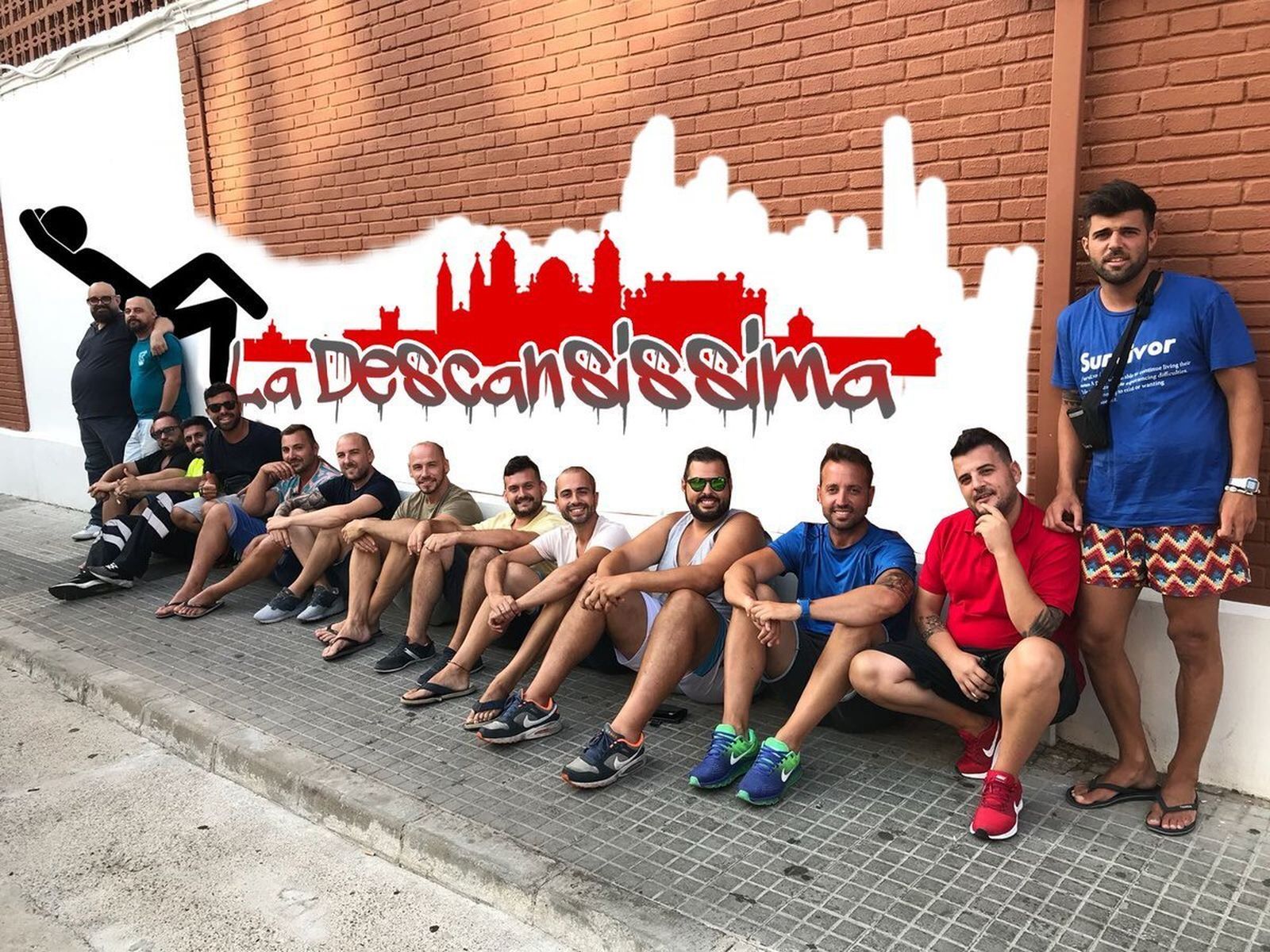Los miembros de la chirigota ante un muro en el que anuncian que descansarán en 2019.