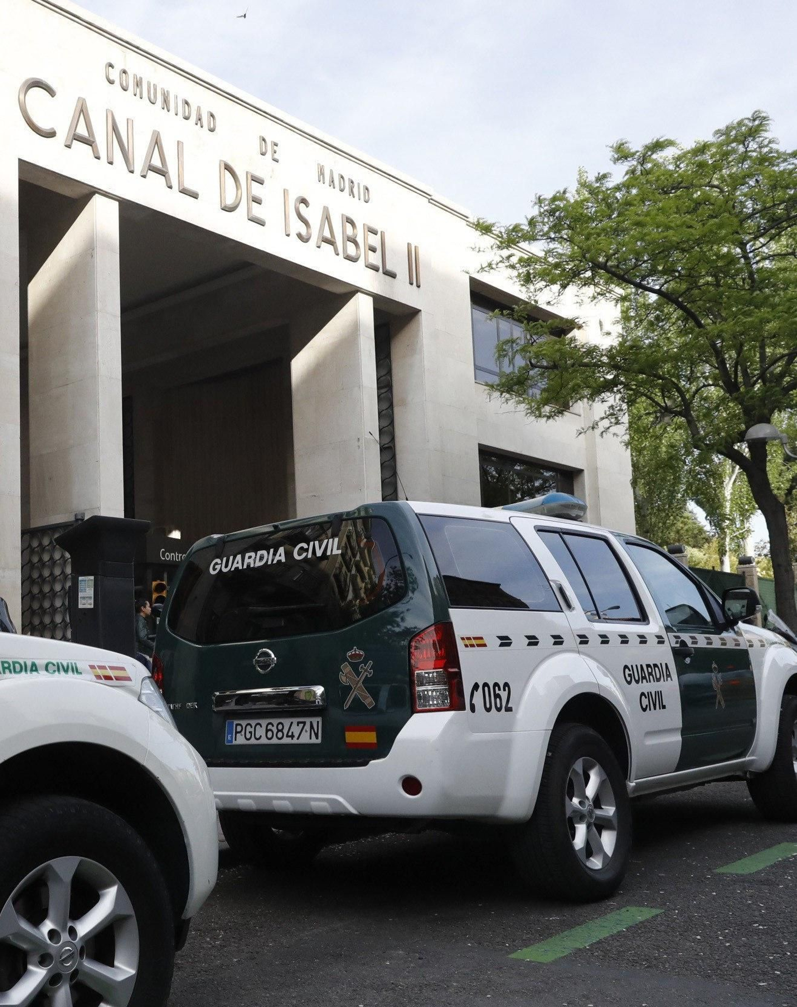 Varios vehículos de la Guardia Civil frente a la sede del Canal Isabel II.
