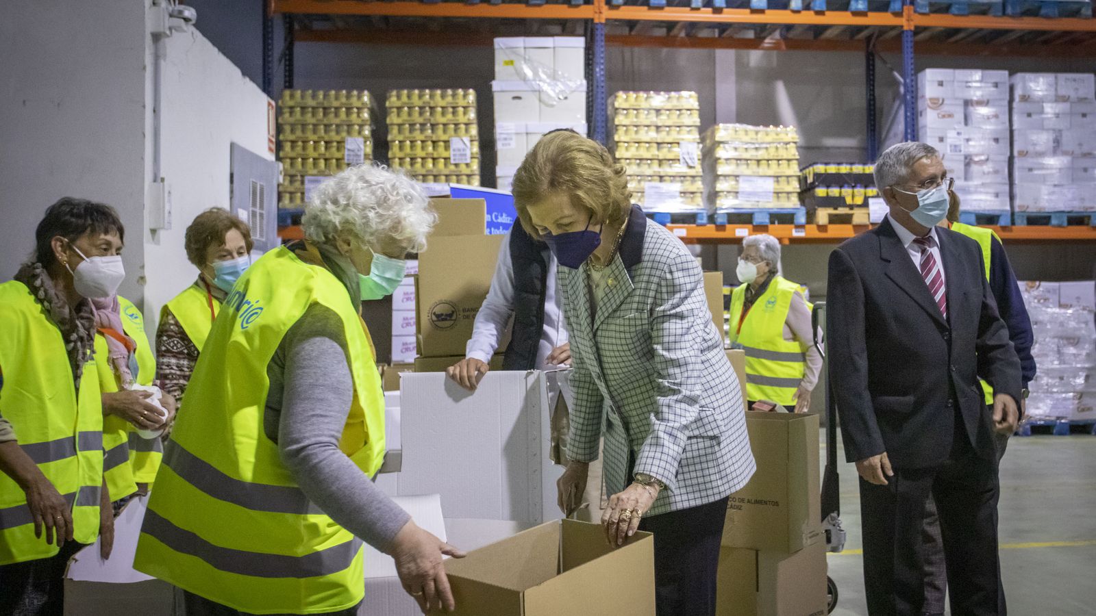 Doña Sofía se interesa por el trabajo de un grupo de voluntarios en una de las naves del Banco de Alimentos.