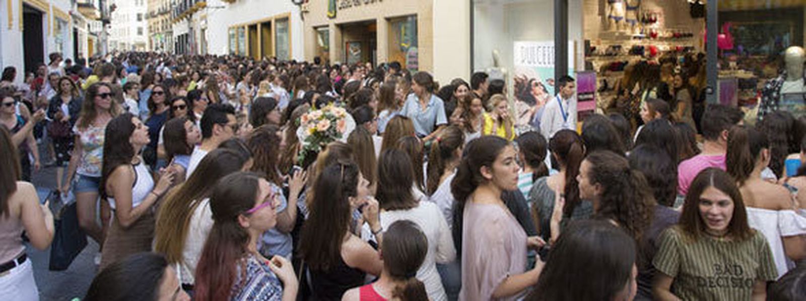 Los jóvenes haciendo cola en la puerta del comercio para ver a la bloguera. / ANTONIO PIZARRO