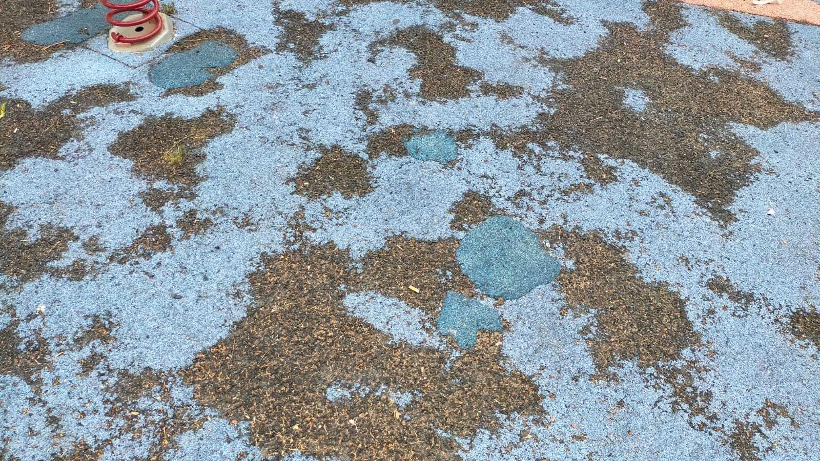 Estado del suelo en un parque infantil de la Barriada de la Paz.