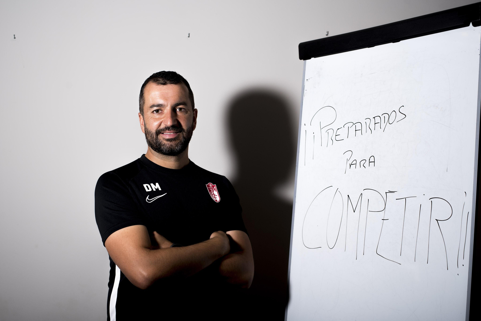 Diego Martínez posa ante una pizarra con el mensaje "preparados para competir".