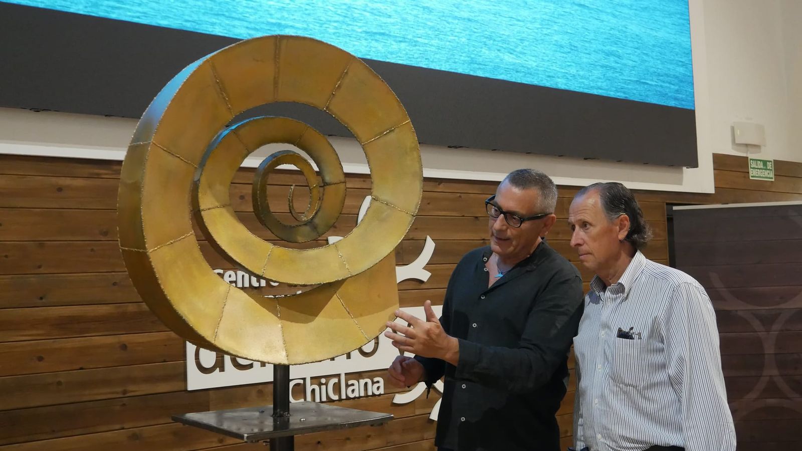 El alcalde atiende las explicaciones del artista.