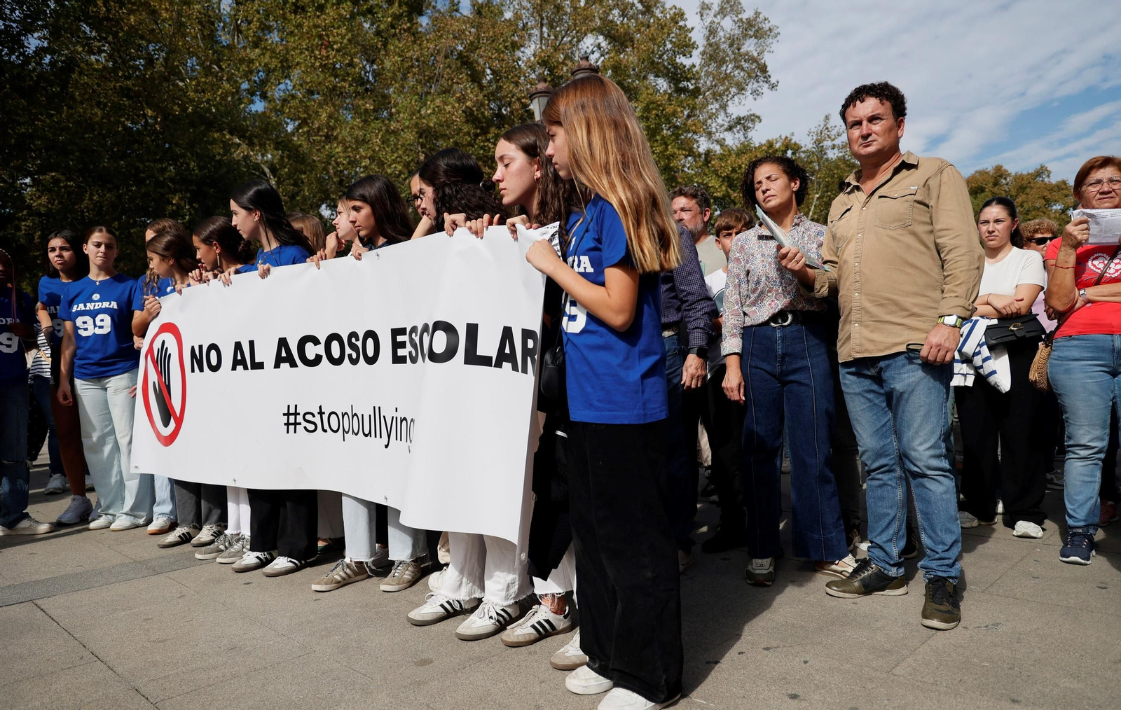 Los padres de Sandra, tras la pancarta en una manifestación contra el acoso escolar.