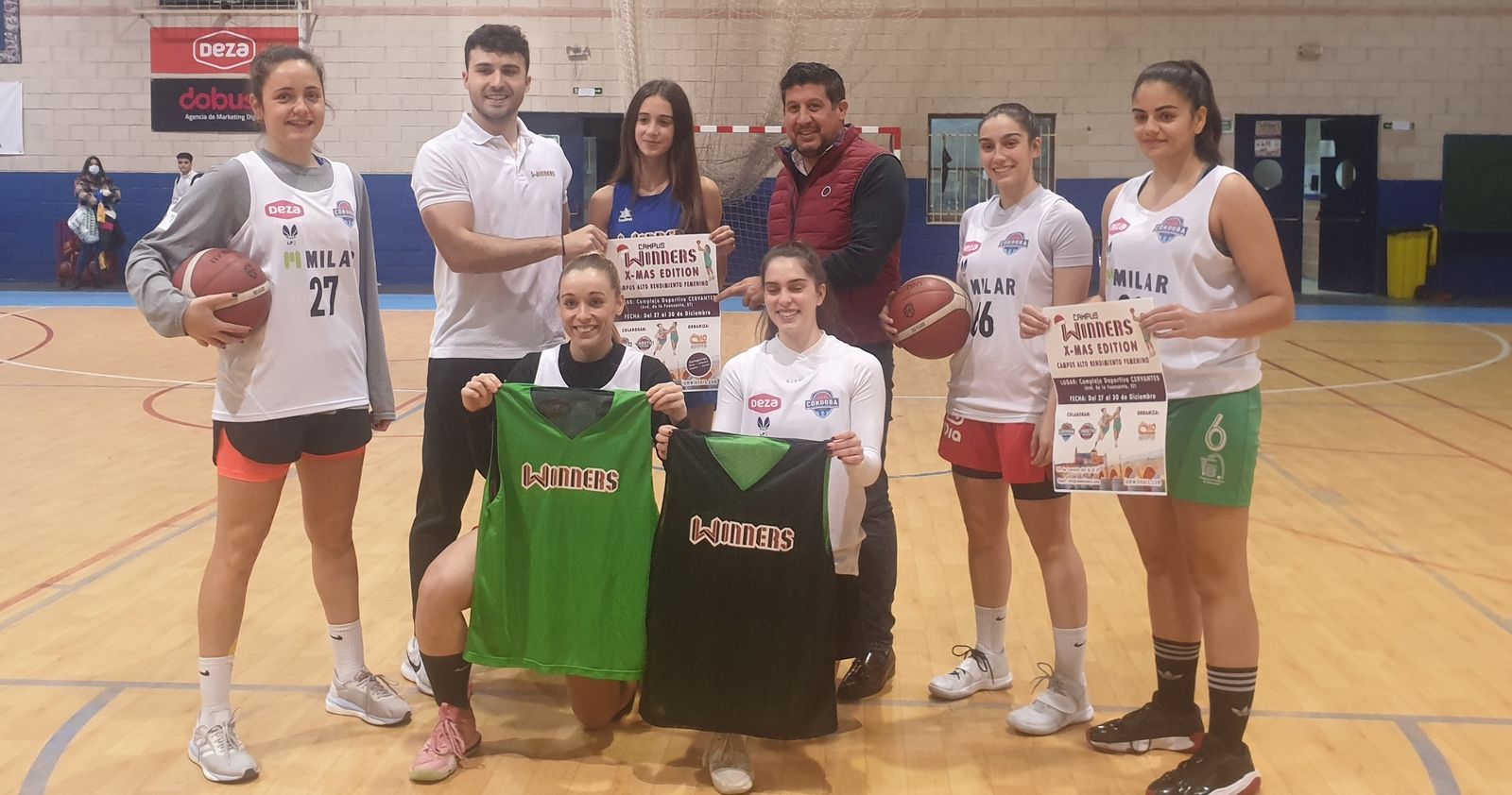 Sebastián del Rey y jugadoras del Milar Córdoba, con el cartel del campus.