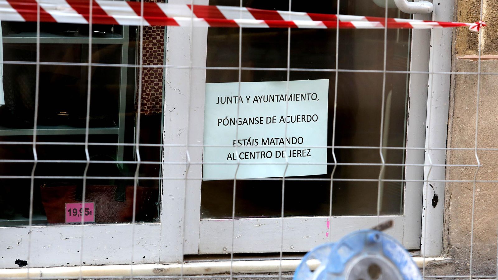Cartel en un comercio de la calle Santa María censurando la actitud de la Junta y el Ayuntamiento en el conflicto del adoquín.