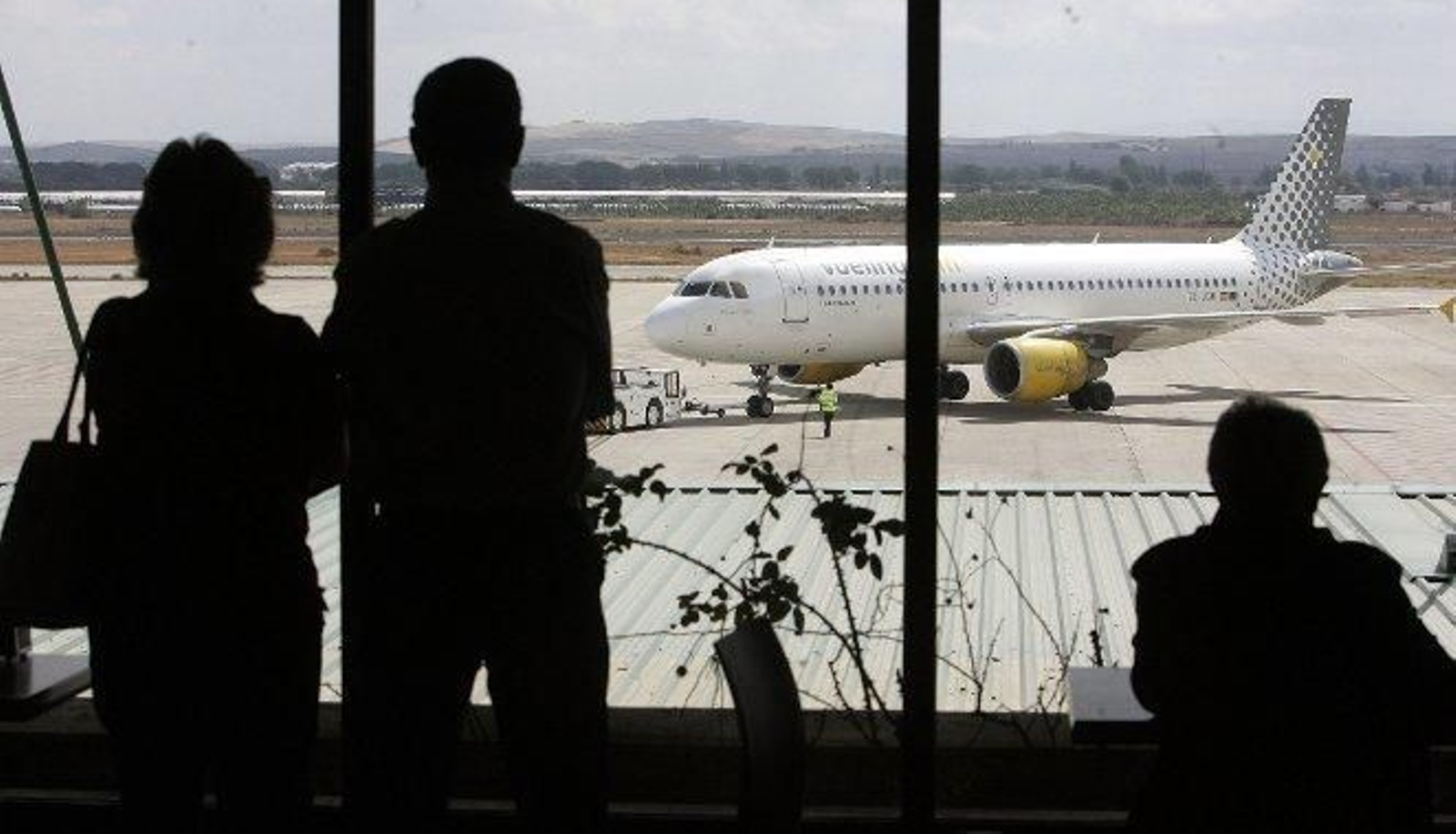 Varias personas observan los movimientos de un avión de Vueling  en la pista de Jerez, en una imagen de archivo.