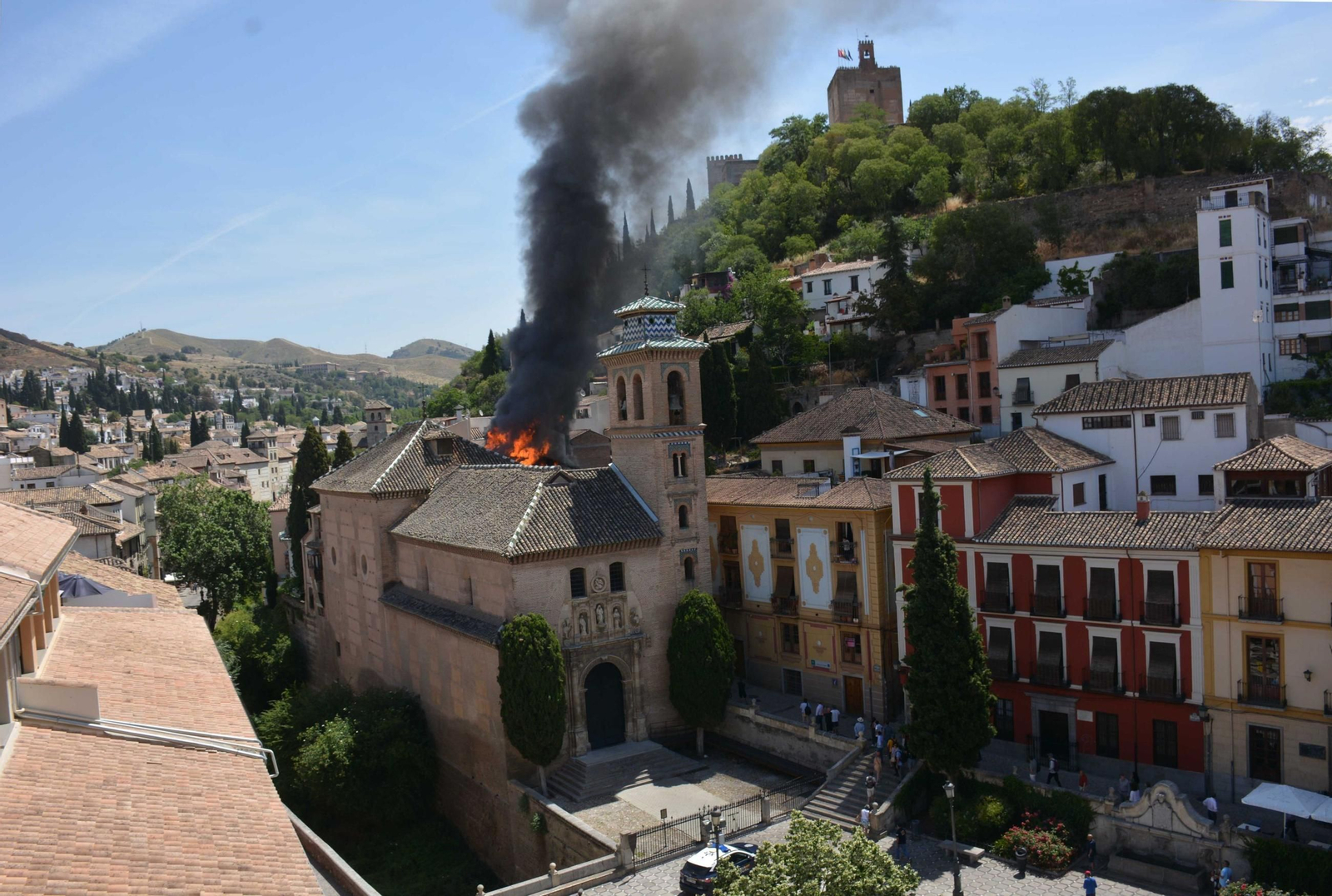 La iglesia de San Gil y Santa Ana, este lunes durante el incendio en un edficio aledaño.