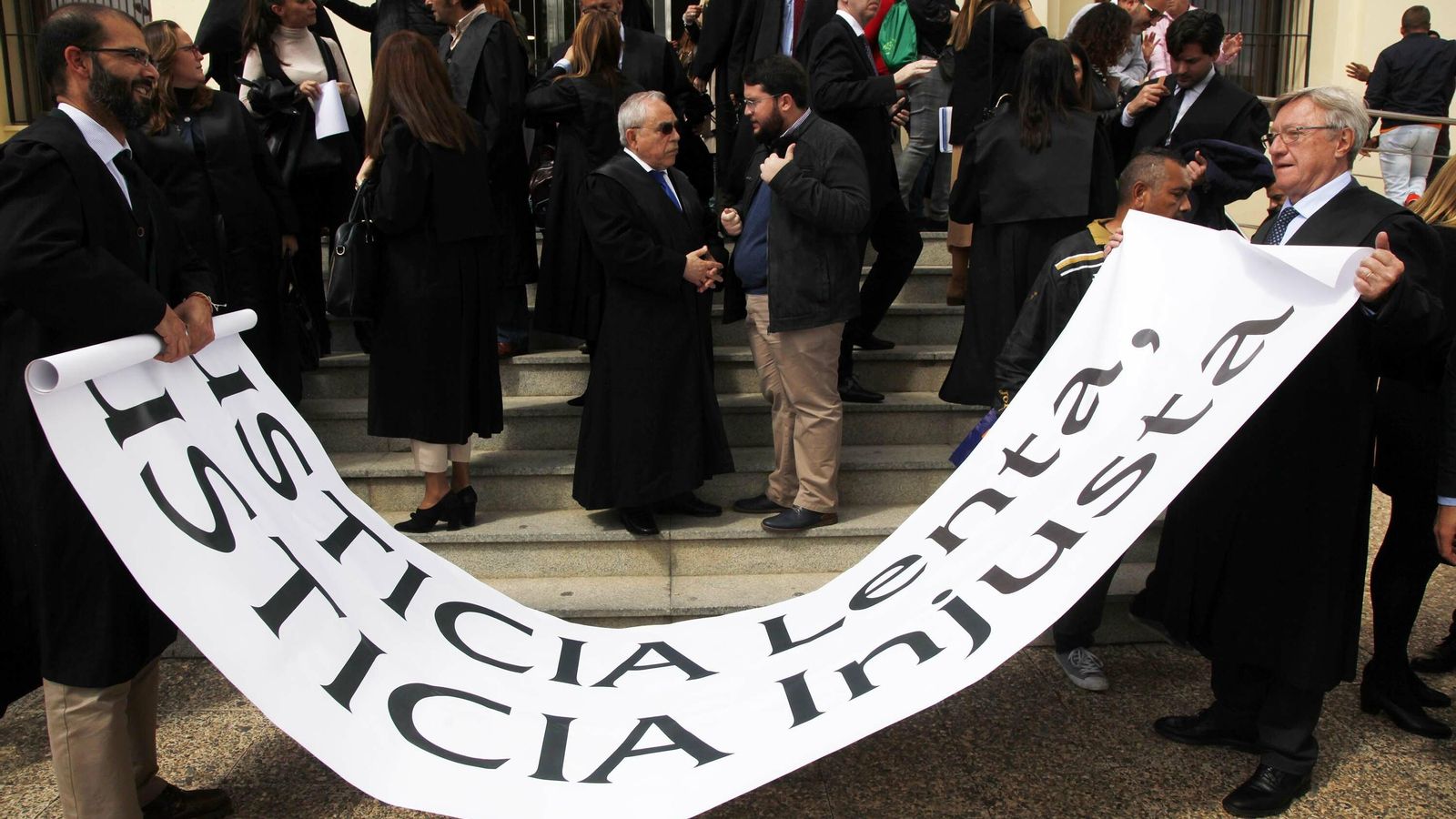 Los participantes en la protesta recogen la pancarta.