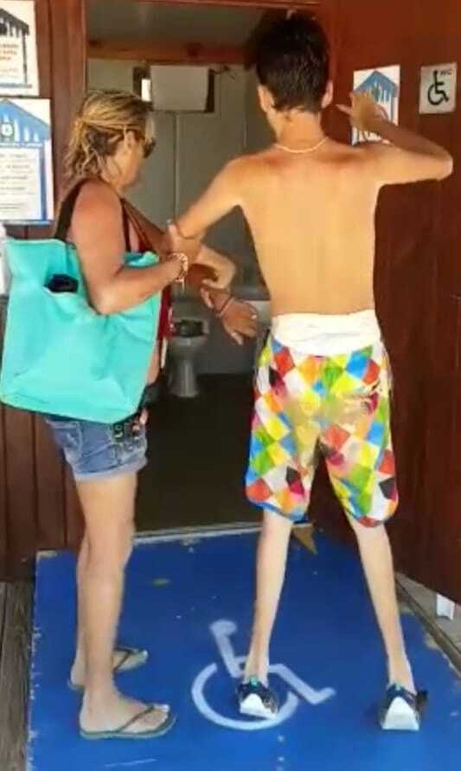 La madre, con el joven discapacitado, en uno de los módulos de la playa de La Muralla.