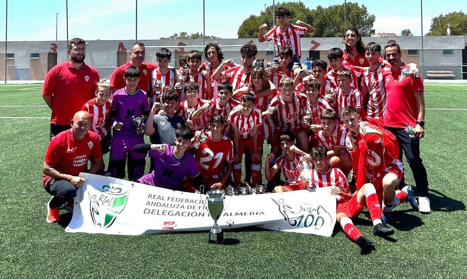 Los jugadores del conjunto rojiblanco y su cuerpo técnico posan con el título de campeón de Segunda Andaluza.