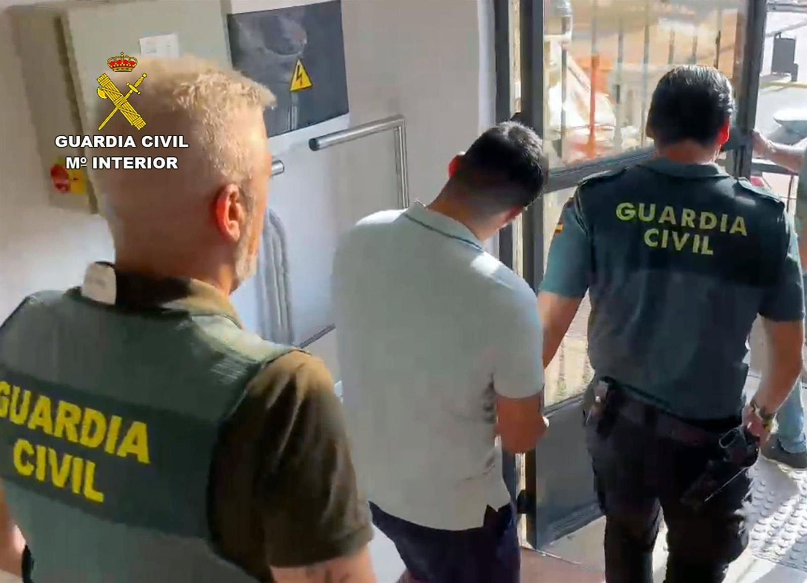 Guardias civiles escoltan a uno de los tres detenidos.