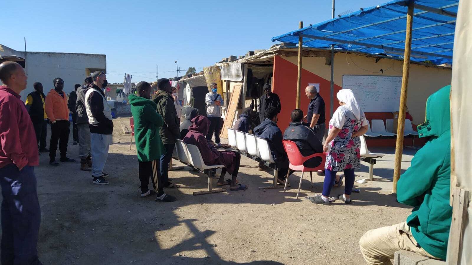 Manuel Blanco durante la formación con sillas y pizarra entre las chabolas