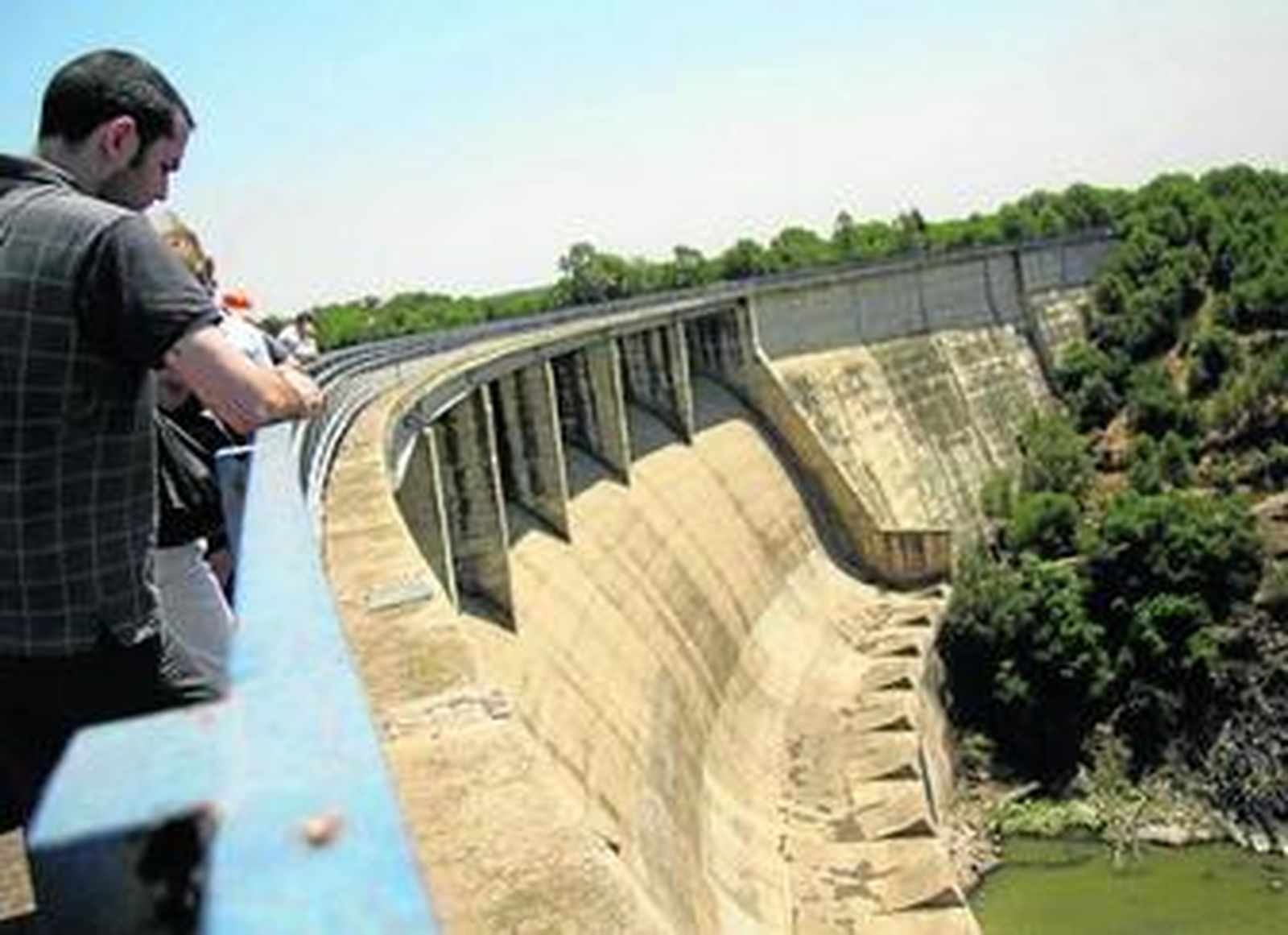 Varias personas visitan la presa del Gergal, en Guillena.