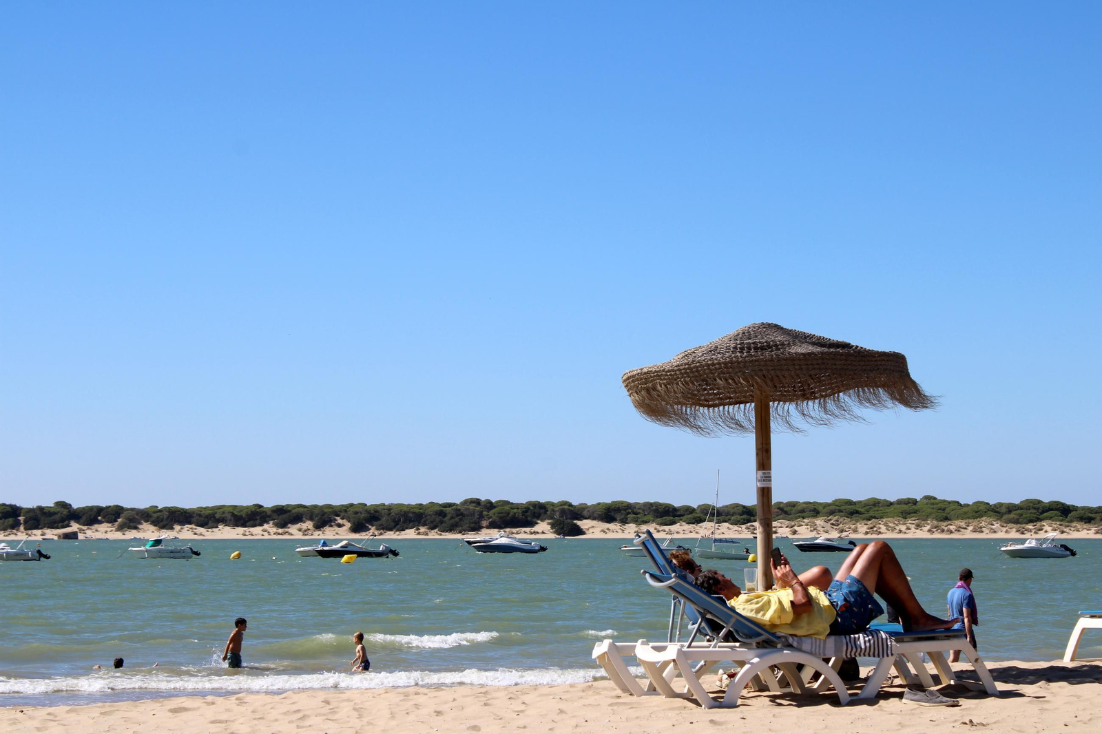 Adultos y pequeños disfrutando de la playa de Sanlúcar.