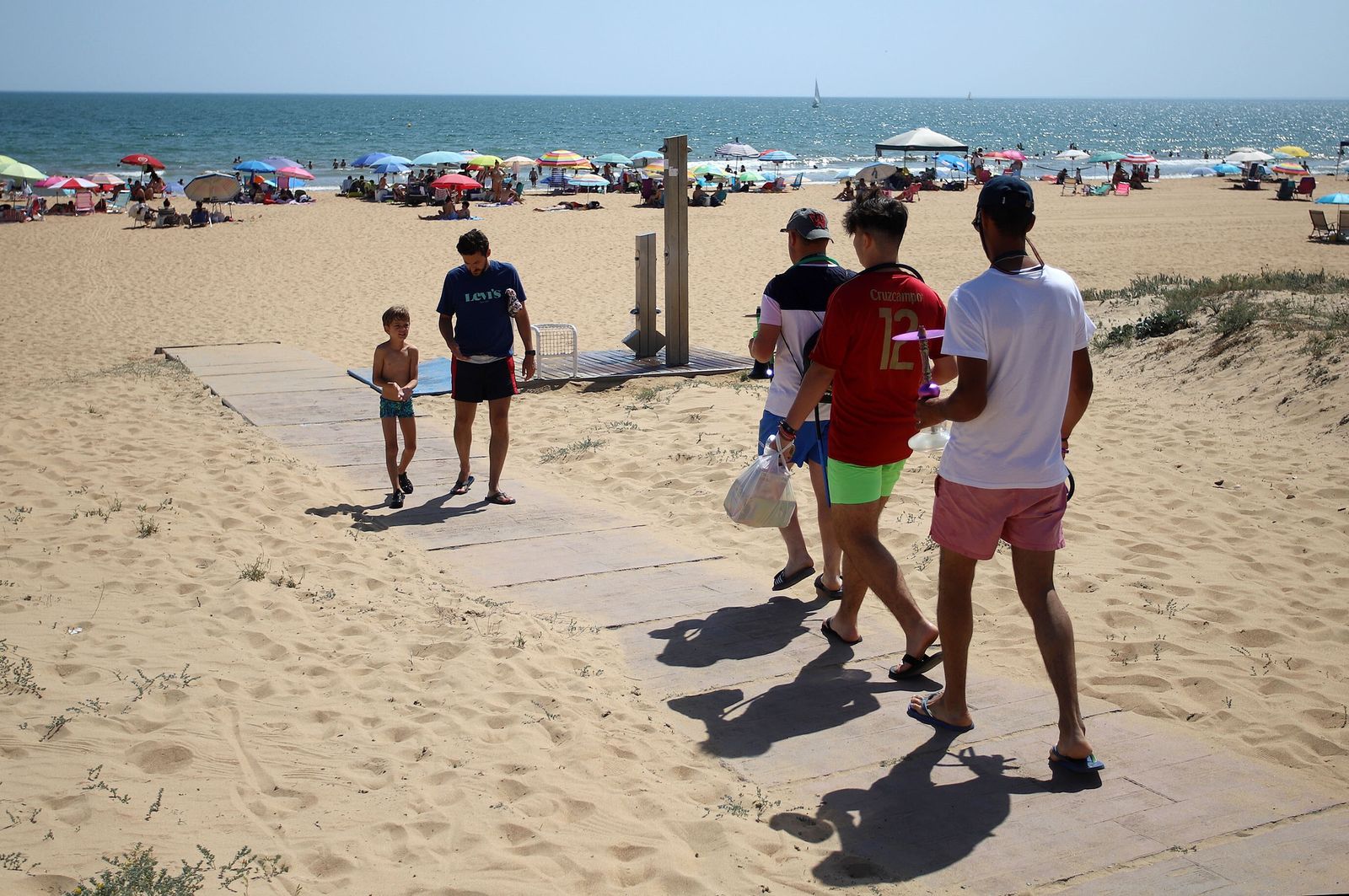 Bañistas disfrutan de un día de calor en la playa de Punta Umbría.