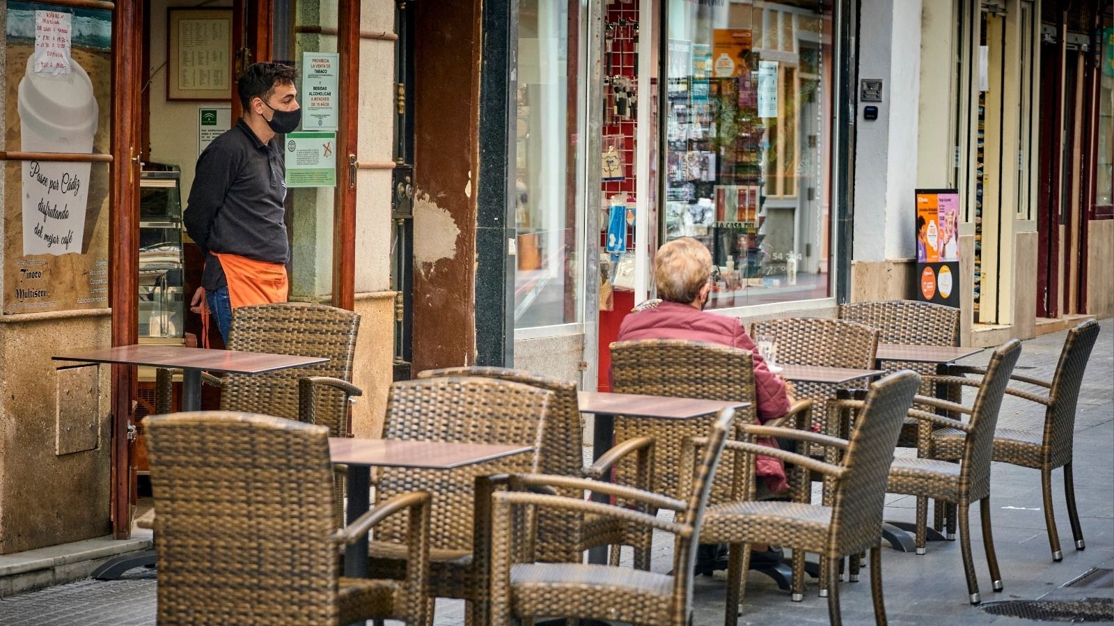 Un camarero en la puerta de un bar