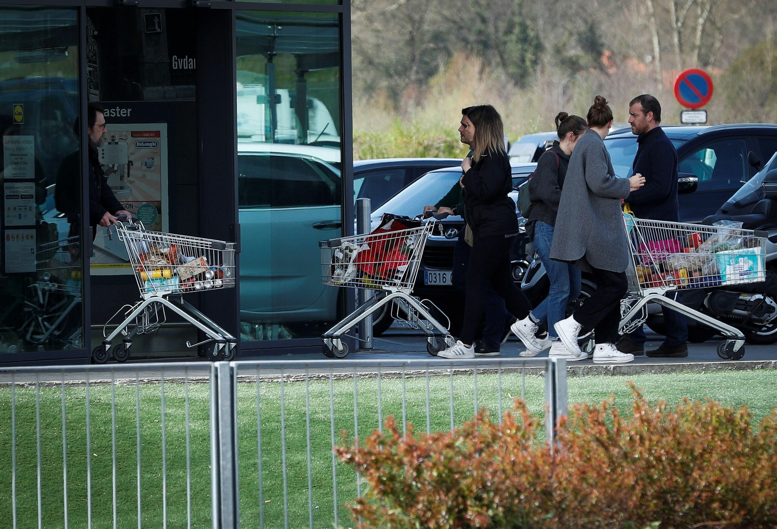 Varias personas con carros haciendo la compra.