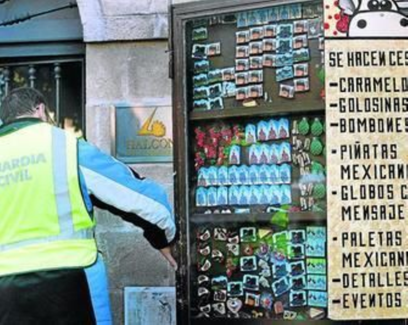 Un agente de Guardia Civil inspeccionando tras la puerta de una tienda de la céntrica plaza del Arenal.