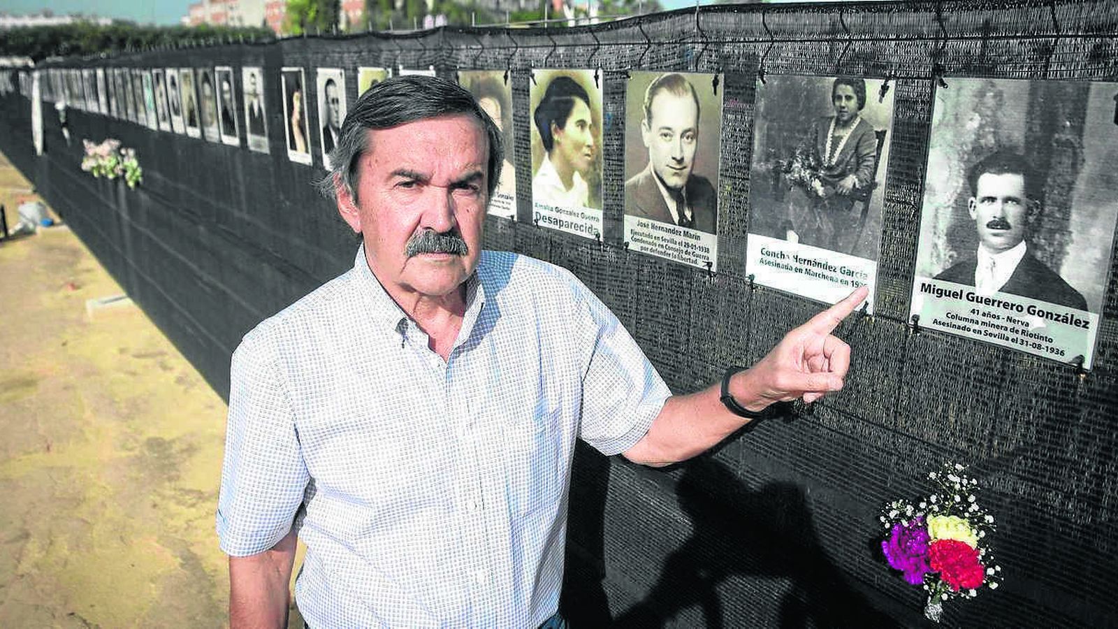 Miguel Guerrero, en la fosa, señalando la fotografía de su abuelo asesinado por el franquismo.