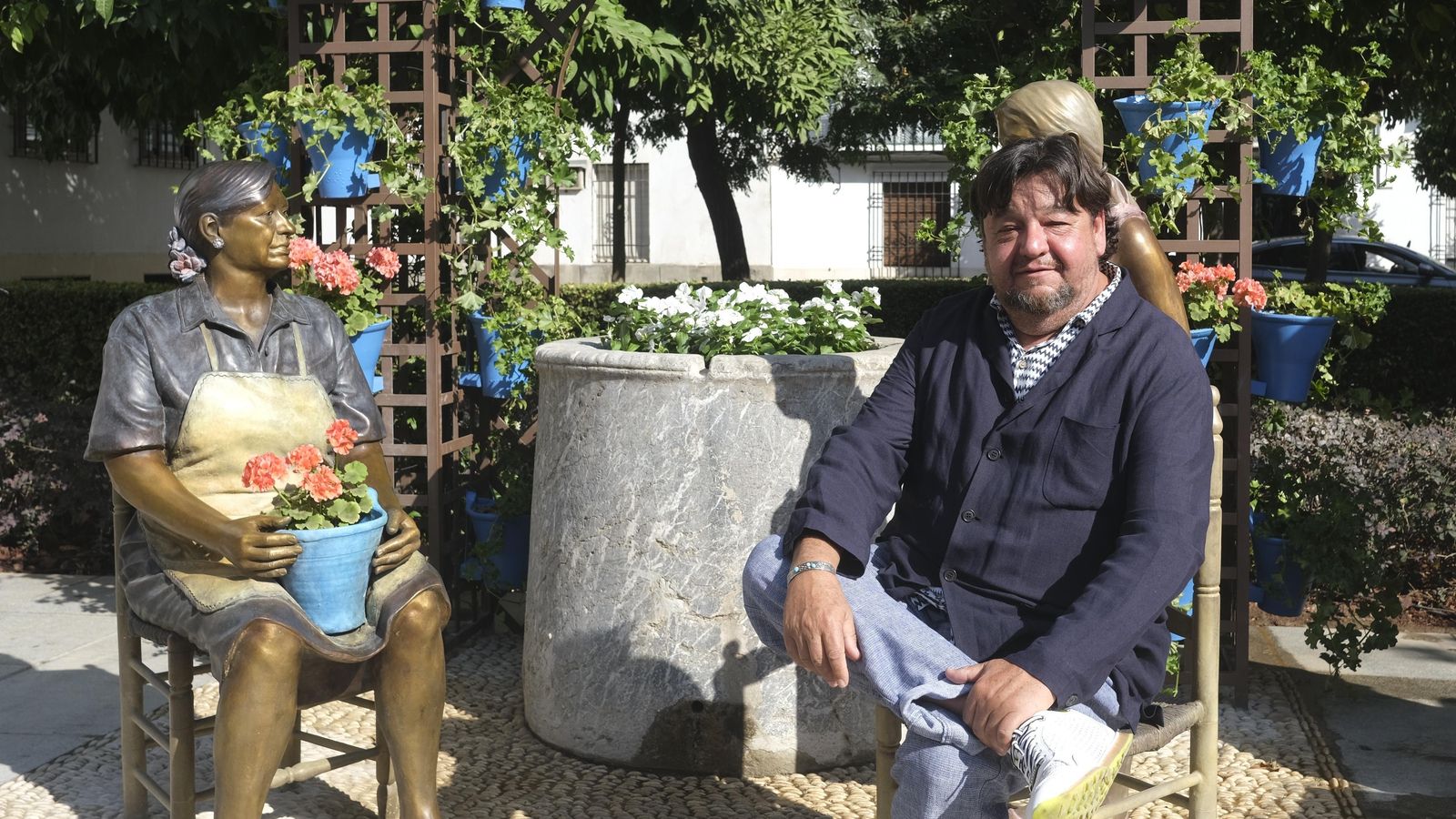 El escultor fotografiado junto a su obra.