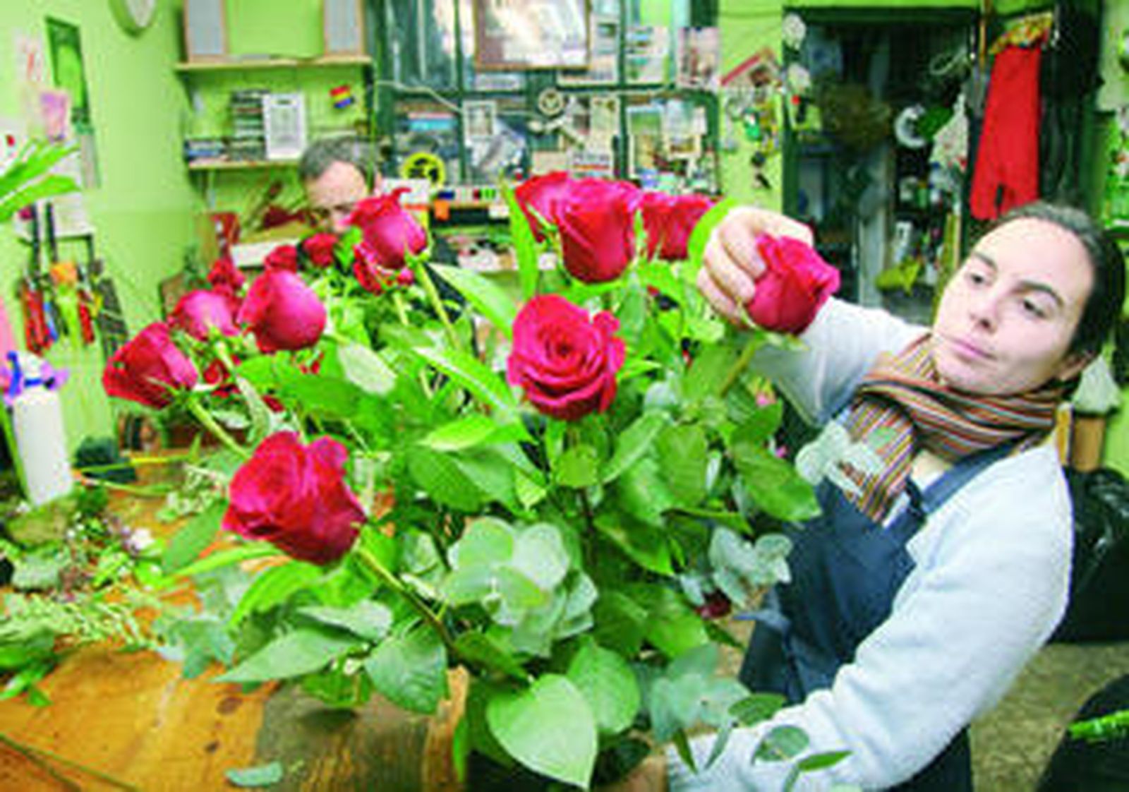 Una de las dependientas de la floristería Los Claveles prepara un ramo de rosas.