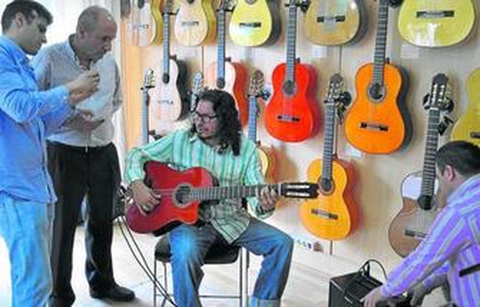 Raimundo Amador prueba su guitarra flanqueado por Mariano Conde, padre e hijo, y Sergio Hernández, de Sevilla Musical.
