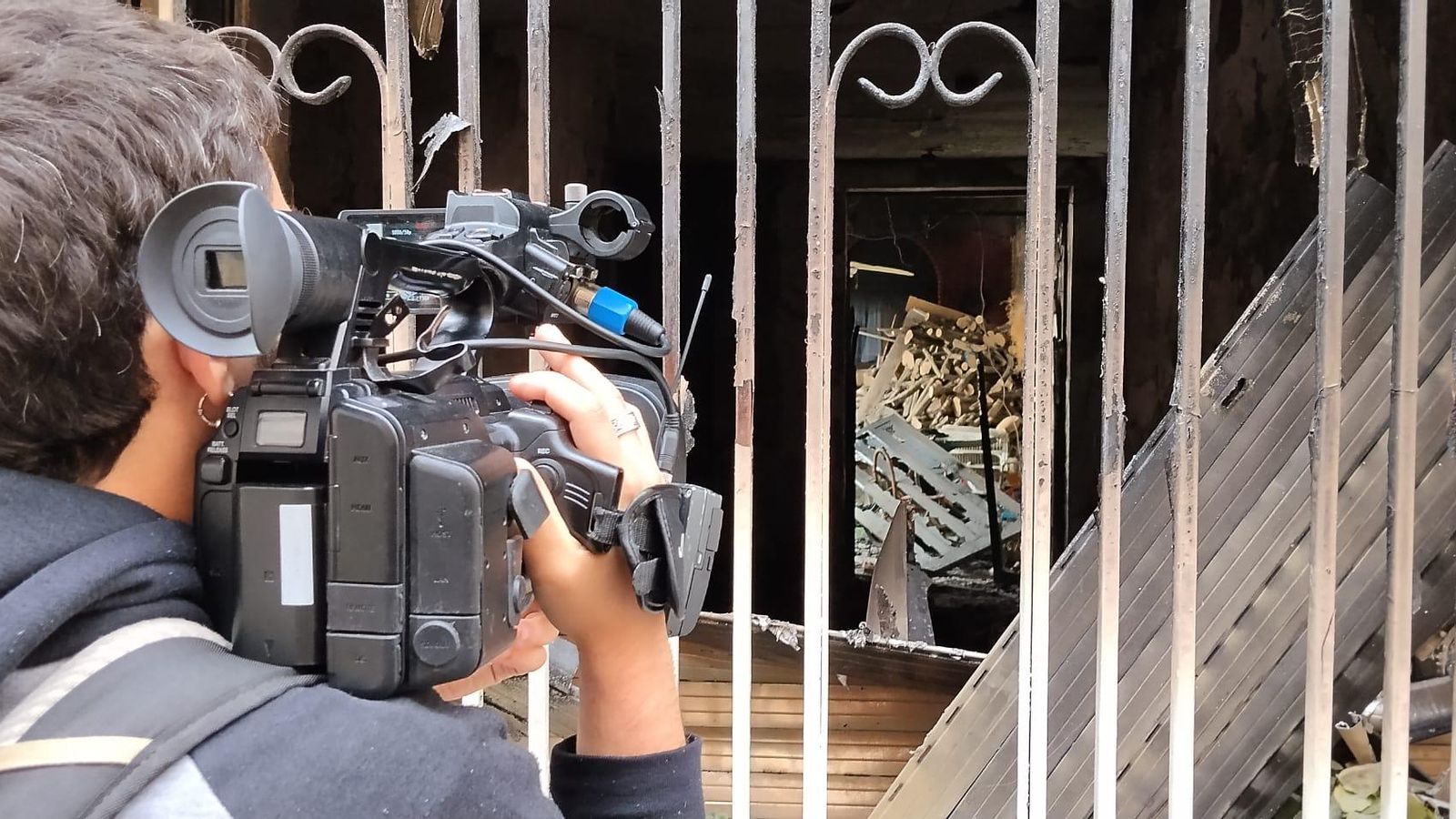 Un cámara de televisión filma el interior de la vivienda quemada en Las Gabias