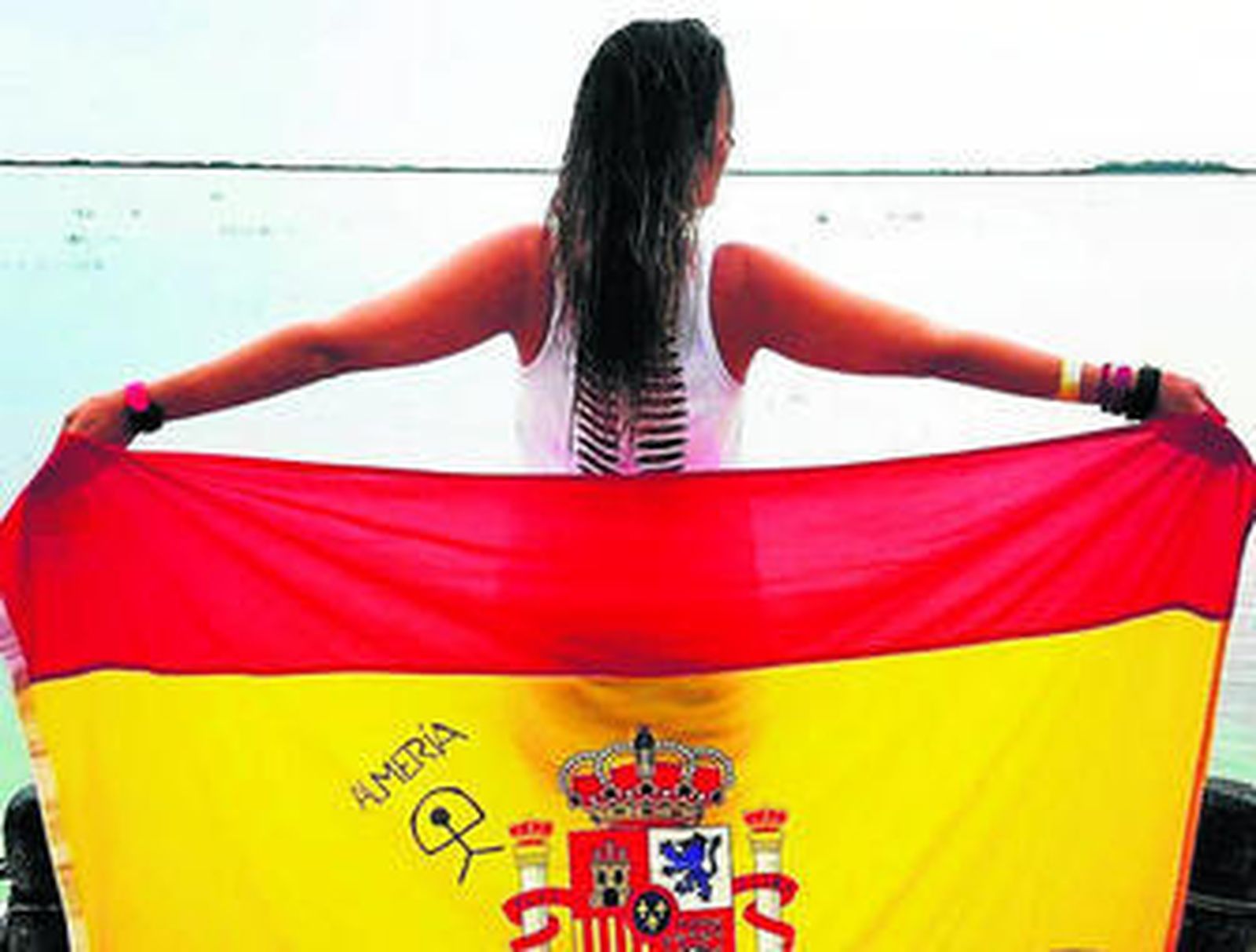 La cantante almeriense Encarna Navarro con la bandera española, el indalo y Almería.